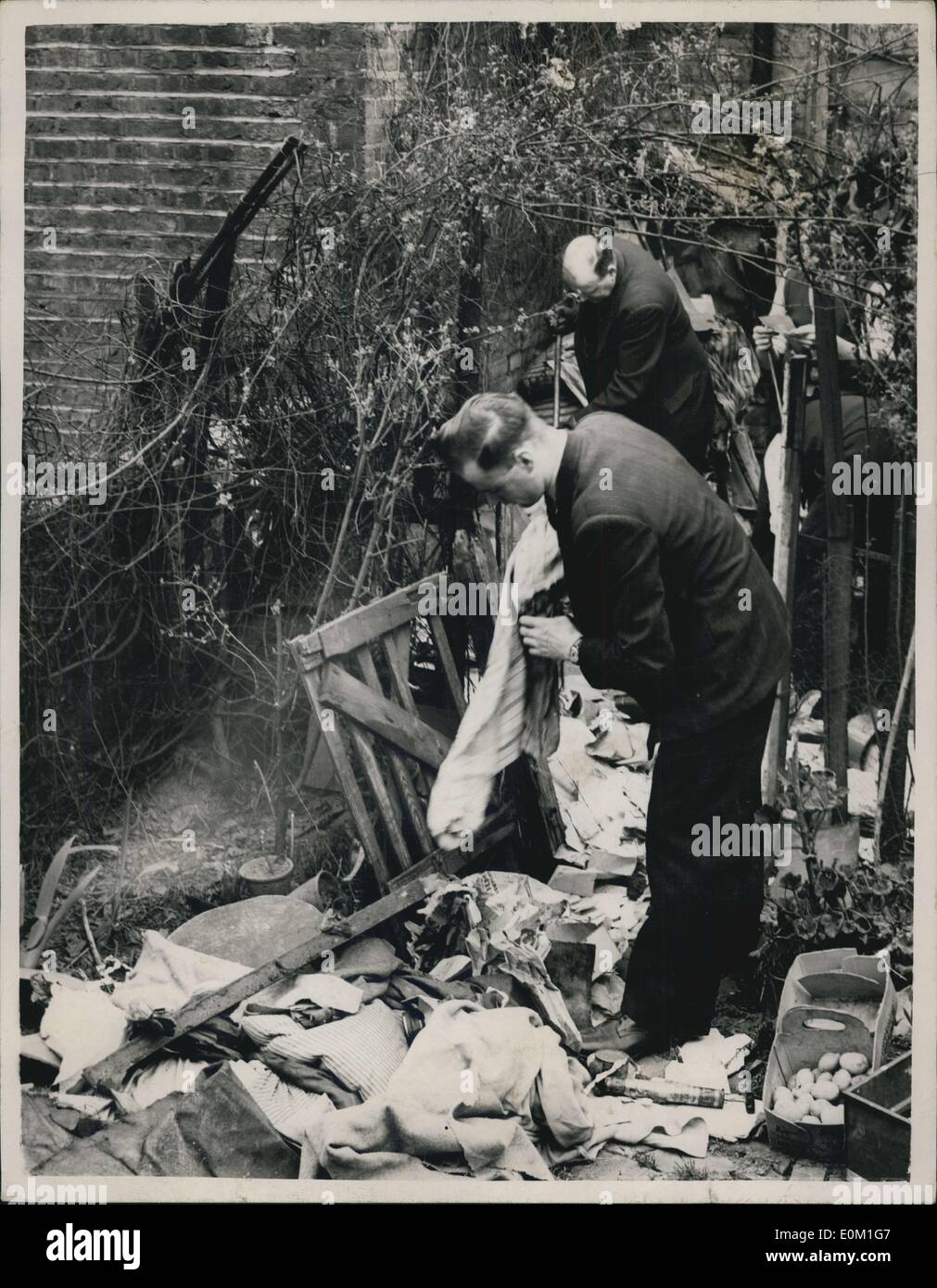 26. März 1953 - Ho Jagd Goes On: Polizei heute wieder ihre Untersuchungen am Haus in Rillington Platz, Notting Hill, wo vier Frauen gefunden erdrosselt und in der Erdgeschosswohnung mit Brettern vernagelt. Das Foto zeigt. Polizisten durchsuchen Müll im Garten des Hauses am Rillington Platz heute. Stockfoto