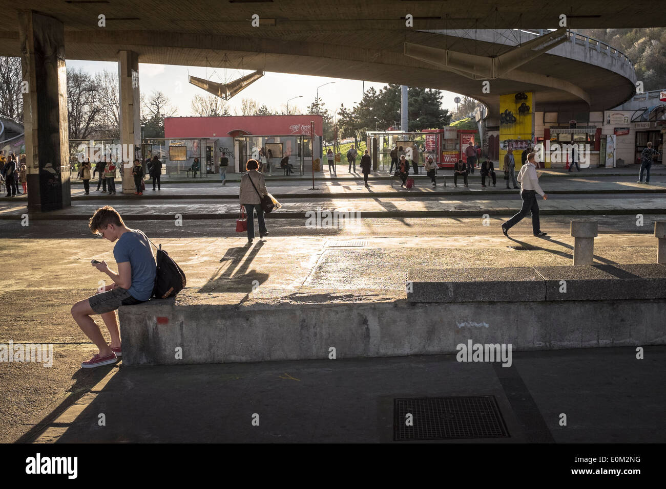 Bushaltestelle unter SNP-Brücke in Bratislava. Ein junger Mann mit seinem Handy Stockfoto