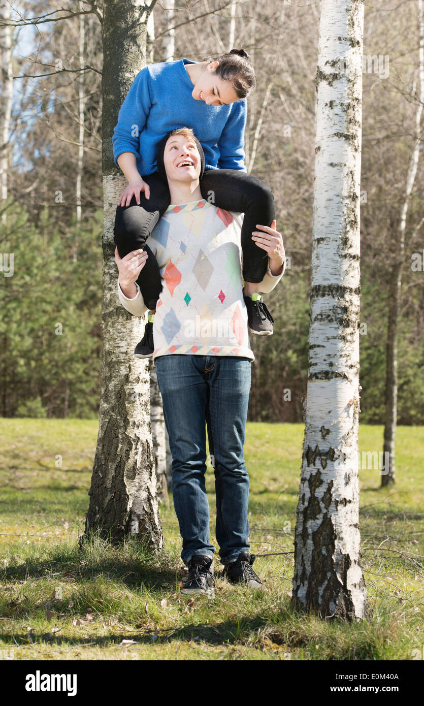 Glückliches Paar inmitten der Natur. Junge Mädchen auf seinen Schultern zu tragen. Stockfoto