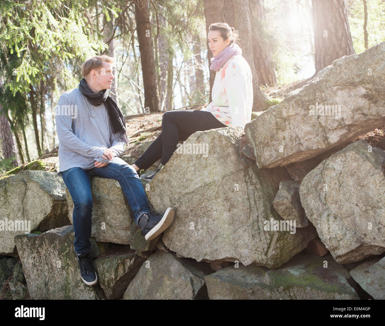 Junges Paar in der Natur auf den großen Felsen in Wäldern während einer Wanderung ausruhen. Stockfoto
