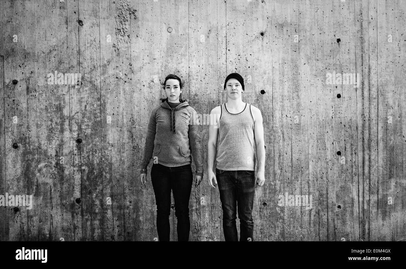 Porträt des jungen Mann und Frau stehen im Stadtgebiet vor Betonwand mit Textfreiraum. Stockfoto