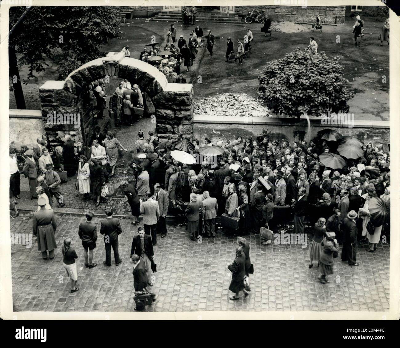 4. August 1953 - ostdeutschen weiter auf Masse in der westlichen Zone For Free Nahrung: Trotz der strengen Beschränkungen auf sie von den sowjetischen Behörden - ostdeutsche in der westlichen Deutsch Zone zuweisen freien Essen Wahlvorschlags an ihnen von den amerikanischen Behörden Gießen weiterhin... Die '' Volkspolizei'' tun alles, was sie, um sie sammeln die Nahrung zu stoppen können- und in vielen Fällen es beschlagnahmt ist, wenn sie in ihre Heimat zurückkehren. Foto zeigt trotz des Regens - warten auf Ost-Berliner für die Nahrungsmittel-Verteilung. Stockfoto