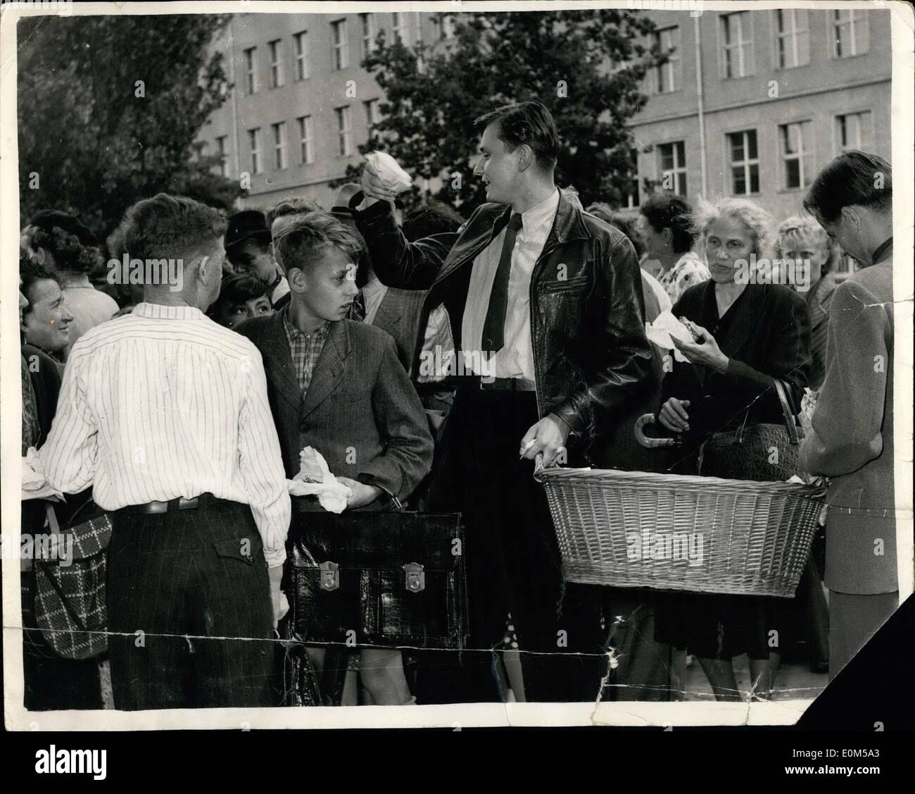 8. August 1953 - ostdeutschen weiter auf Masse in der westlichen Zone For Free Nahrung: Trotz der strengen Beschränkungen auf sie von den sowjetischen Behörden - ostdeutschen weiterhin Gießen in der westlichen Zone, das kostenlose Essen Wahlvorschlags an ihnen von den amerikanischen Behörden zu sammeln. Die '' Volkspoliszei'' tun alles, was sie tun können, stoppen sie sammeln die Nahrung - und in vielen Fällen es beschlagnahmt ist, wenn sie in ihre Heimat zurückkehren. Foto zeigt, dass Studenten verteilen Brot warten Massen der ostdeutschen - in Berlin - warten auf die Verteilung von Nahrungsmitteln. Stockfoto