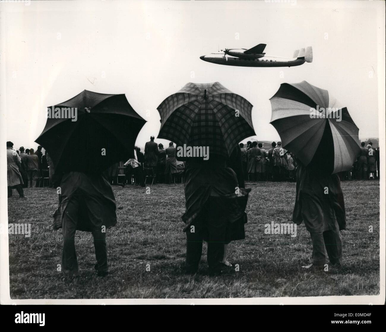 Sept. 09, 1954 - die Farnborough Air Show - fliegen - im Zug gerade öffentlich: Foto zeigt die Szene auf der Farnborough Air Show heute Nachmittag wie Mitglieder der Öffentlichkeit welchen Schutz bekommen sie können vor dem Regen - mit ihren Regenschirmen, wie sie eine Flugvorführung maschinell Proteus Botschafter der Bristol Aeroplane Company zu sehen. Stockfoto
