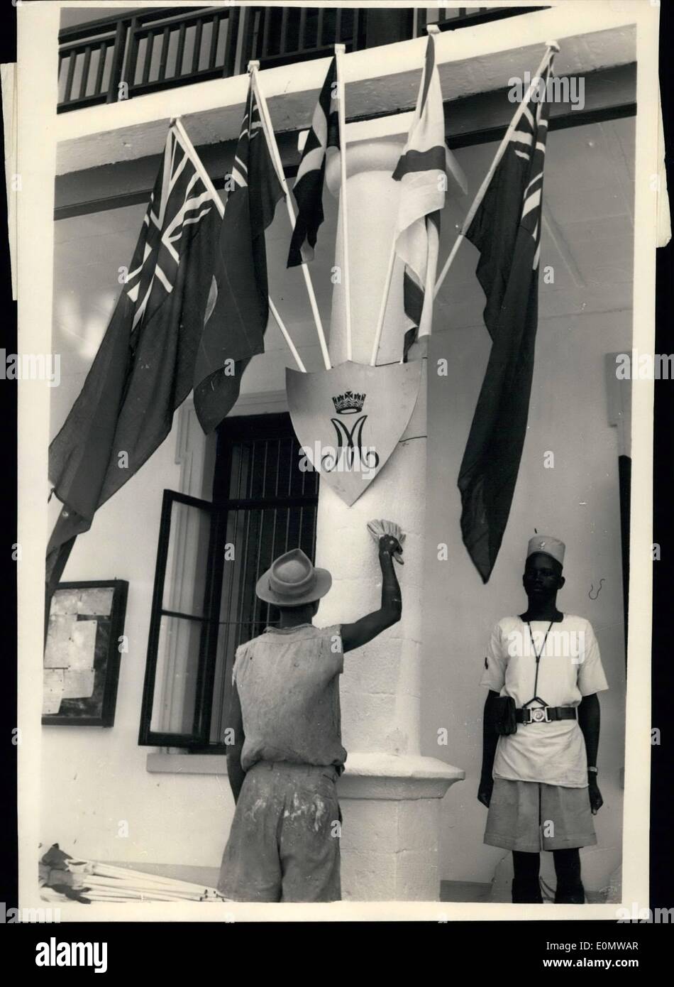 Sept. 09, 1956 - U.A. Pool Vorbereitungen für die königliche Tour: Mombasa, Kenia: ein Arbeiter ist sehr beschäftigt mit seinen weißen waschen Pinsel unter einem Mantel aus Fahnen befestigt, ein Schild mit dem Monogramm '' M'' das für Margaret, in den Büros der Zentralregierung in Mombasa in Vorbereitung auf die königliche Tour von Prinzessin Margaret, die England Morgen verlässt. Stockfoto