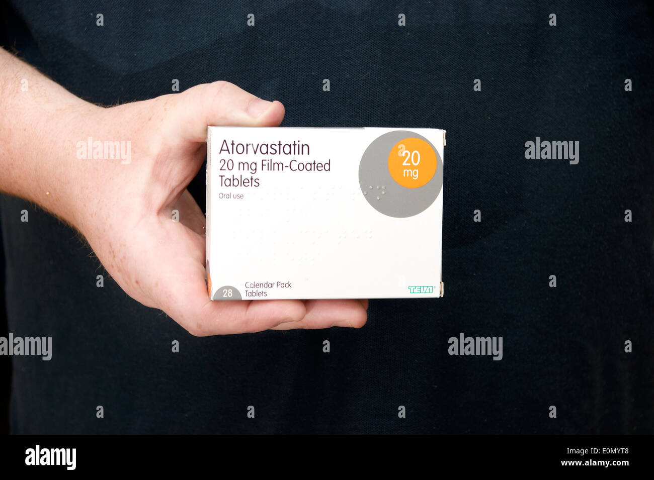 Mann hält eine Schachtel mit Atorvastatin Tabletten (Statine) Stockfoto