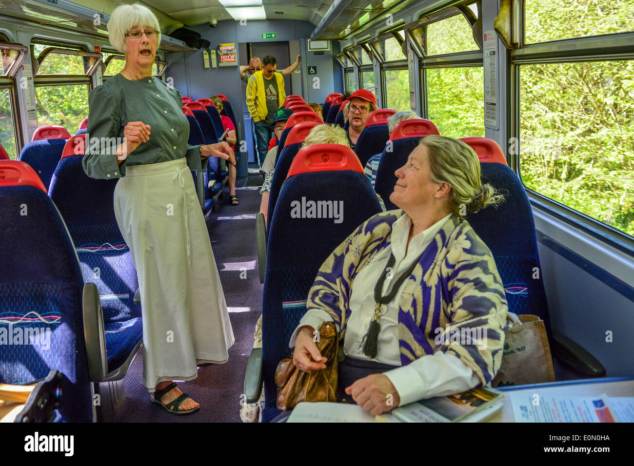 Looe, Großbritannien. 16. Mai 2014. Freitag, 16. Mai 2014 Bild von Sean Hernon.  Passagiere auf Looe Valley Line werden durch Geschichten der Bergleute und Bal Maidens, Fischer unterhalten, wie sie entlang der schönen Looe Valley Reisen. Lokalen Geschichtenerzähler in Tracht gekleidet werden die landschaftlich schöne Strecke zwischen Liskeard und Looe im Rahmen des Kunstfestivals Vital Spark in South East Cornwall beitreten. Anne Hughes singt für die Passagiere © Sean Hernon/Alamy Live News Bildnachweis: Sean Hernon/Alamy Live News Stockfoto