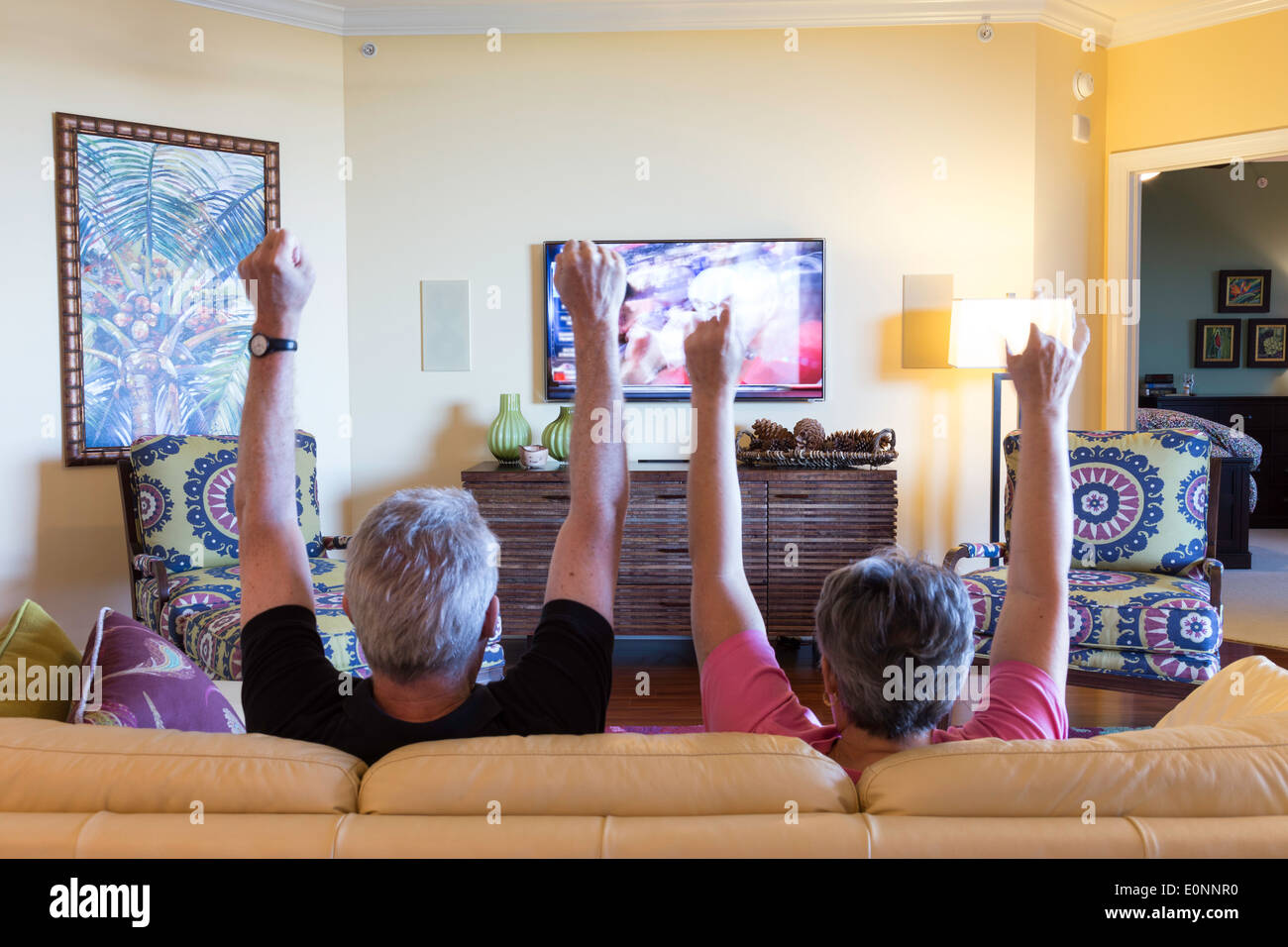 Reifes Paar, Fußball Spiel eine Gestik, die Touchdown auf TV (Fernsehen) im Schaufenster Wohnhaus, USA Stockfoto
