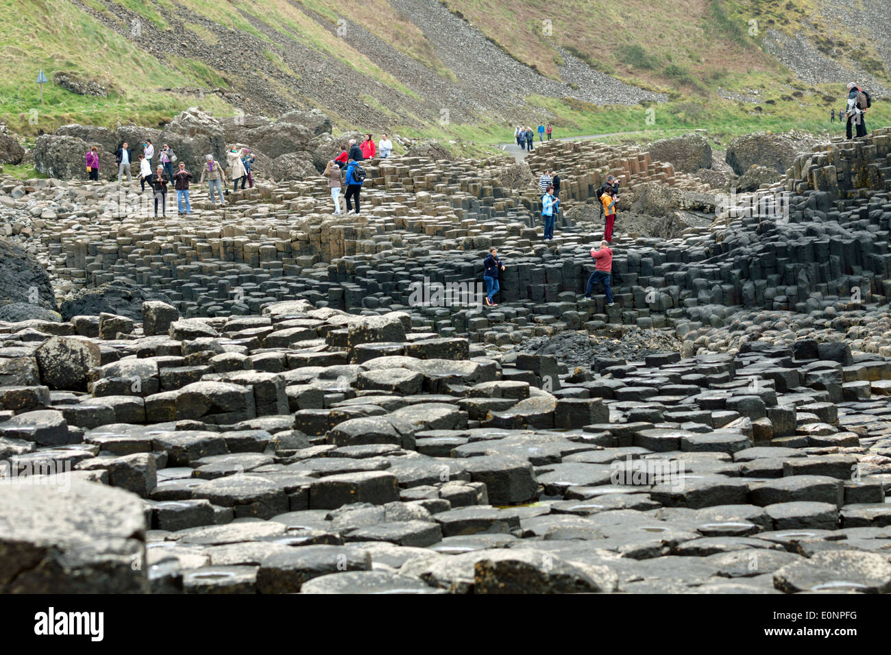 Touristen erkunden den Giant's Causeway, County Antrim, Nordirland, Vereinigtes Königreich, einem berühmten UNESCO-Weltkulturerbe. Stockfoto