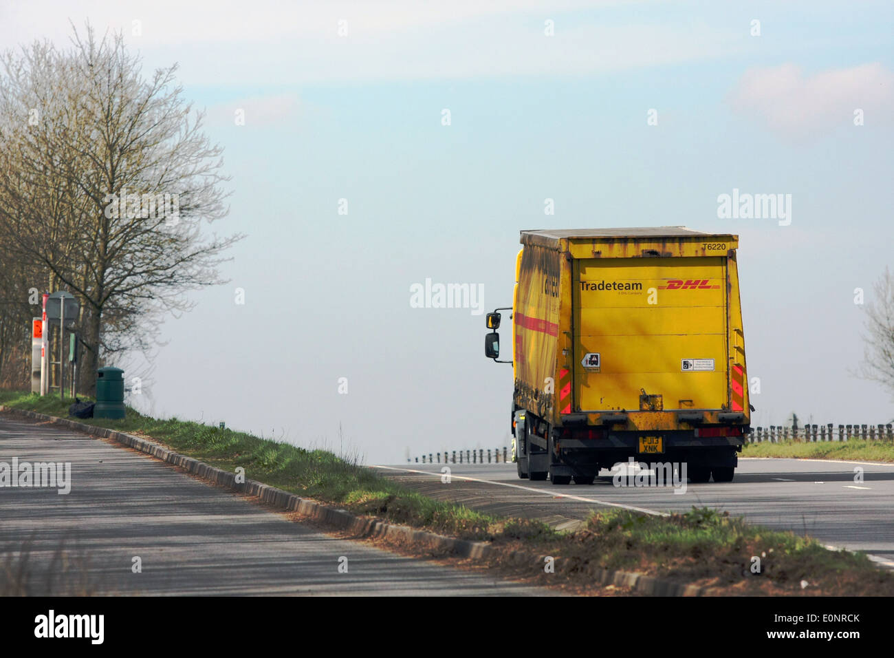 Ein DHL-LKW vorbei am Eingang zu einer Layby während der Fahrt entlang der Schnellstraße A417 in Cotswolds, England. Stockfoto