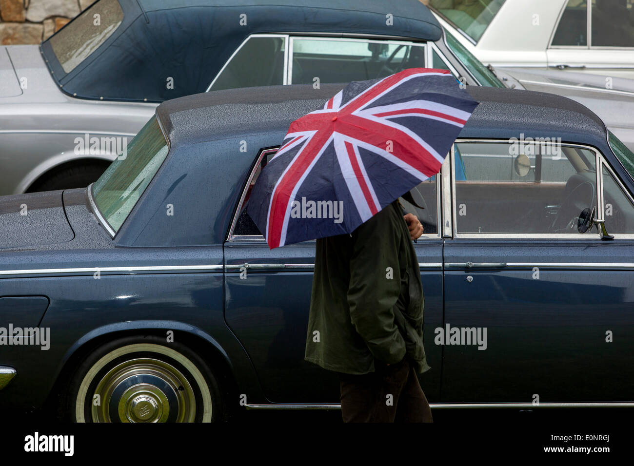 Ein Mann mit der Union Jack Regenschirm zwischen den Autos. Sitzung des Rolls-Royce in Dubec in der Nähe von Prag. Der Tschechischen Republik Stockfoto