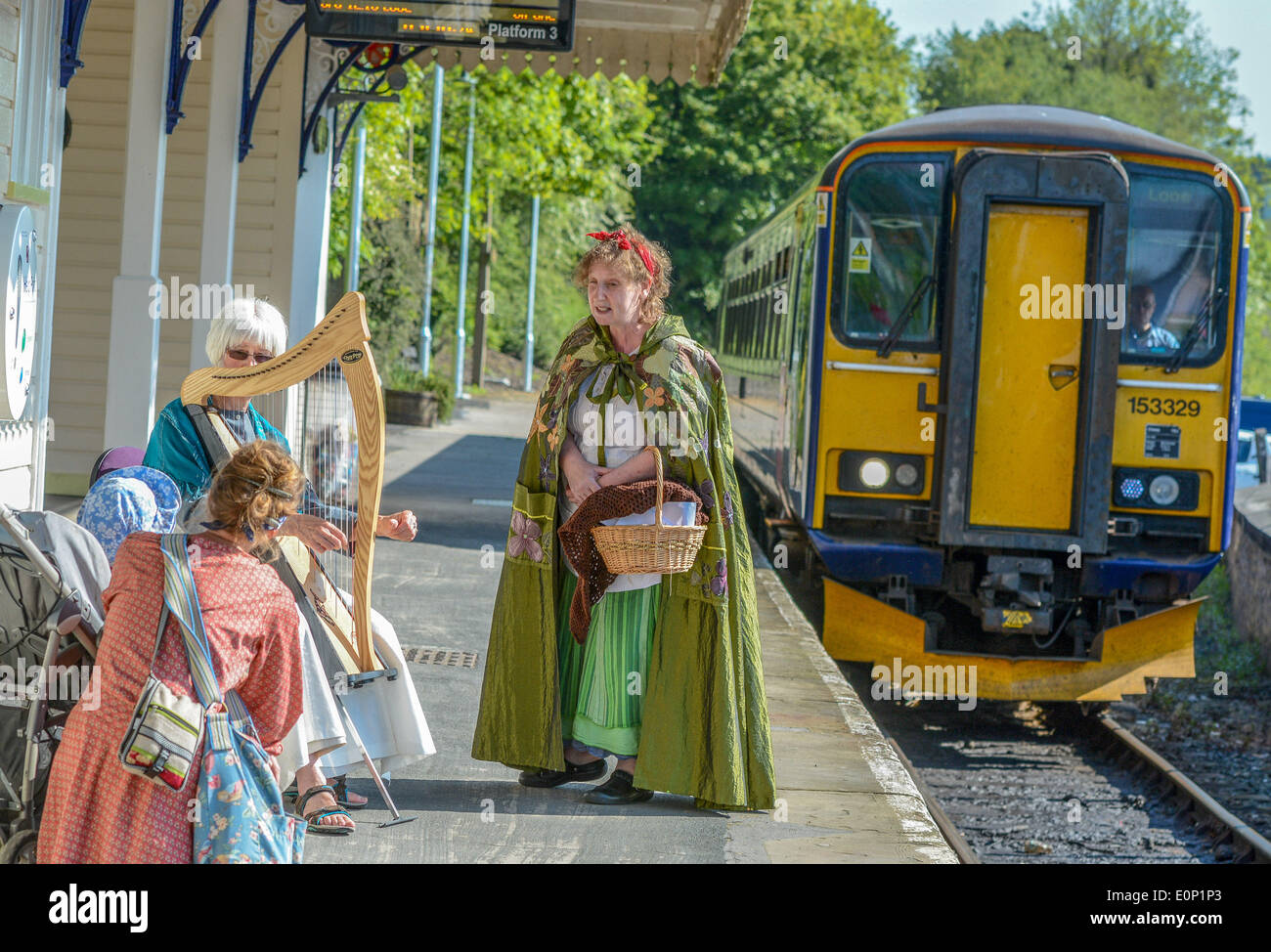 Talweg Looe, Cornwall, UK. 16. Mai 2014. Passagiere auf Looe Valley Line werden durch Geschichten der Bergleute und Bal Maidens, Fischer unterhalten, wie sie entlang der schönen Looe Valley Reisen. Lokalen Geschichtenerzähler in Tracht gekleidet werden die landschaftlich schöne Strecke zwischen Liskeard und Looe im Rahmen des Kunstfestivals Vital Spark in South East Cornwall beitreten. Anne Hughes auf Harfe und Liz Berg erzählen der Winzling eine Geschichte, als der Zug in den Bahnhof am Liskeard ziehen. Bildnachweis: Sean Hernon/Alamy Live-Nachrichten Stockfoto