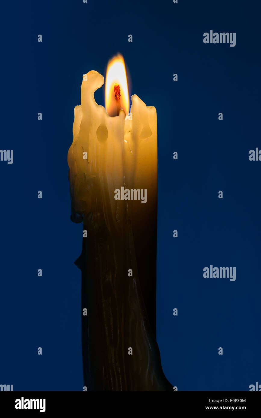 Eine Kerze mit einer Flamme in der blauen Nacht Stockfoto