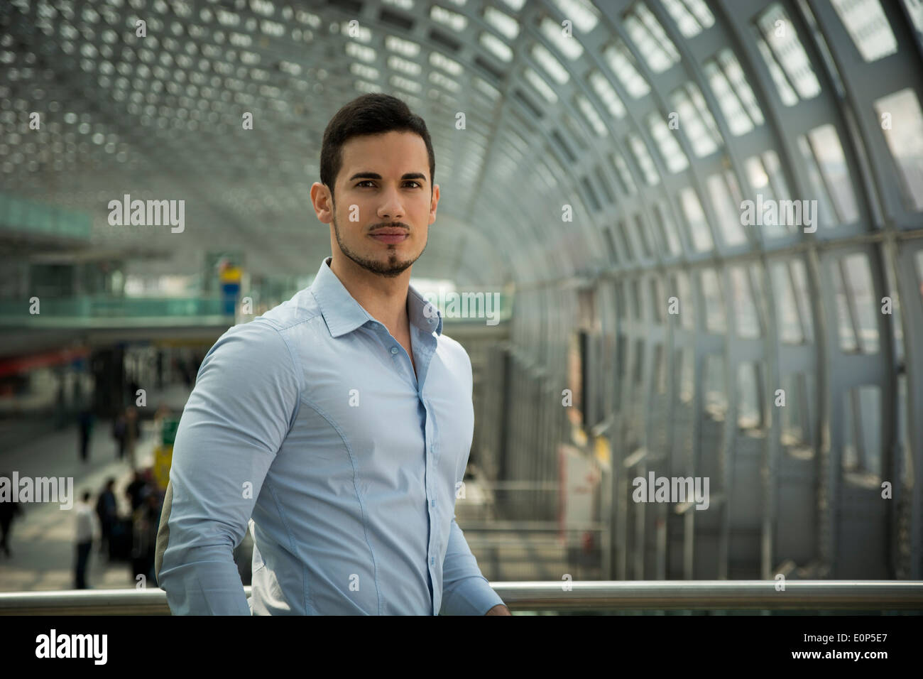 Hübscher junger Mann im Bahnhof oder Flughafen, Blick in die Kamera Stockfoto