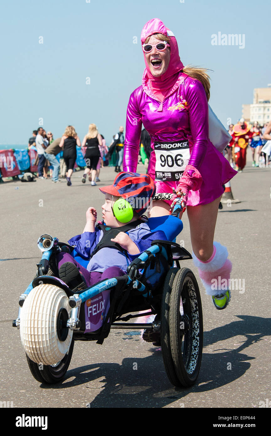 Brighton, UK. 18. Mai 2014. Die Ziellinie der Nächstenliebe Volkslauf auf Hove Promenade, um Gelder für, übergeben sie an Afrika. Verkleidet als Helden oder Schurken, die sie in der Sonne - einige mehr ernst nehmen als andere entlang sprint. die Kinder Rennen einen 500metre Kurs, Erwachsene, 5K oder 10K. Bildnachweis: Julia Claxton/Alamy Live-Nachrichten Stockfoto