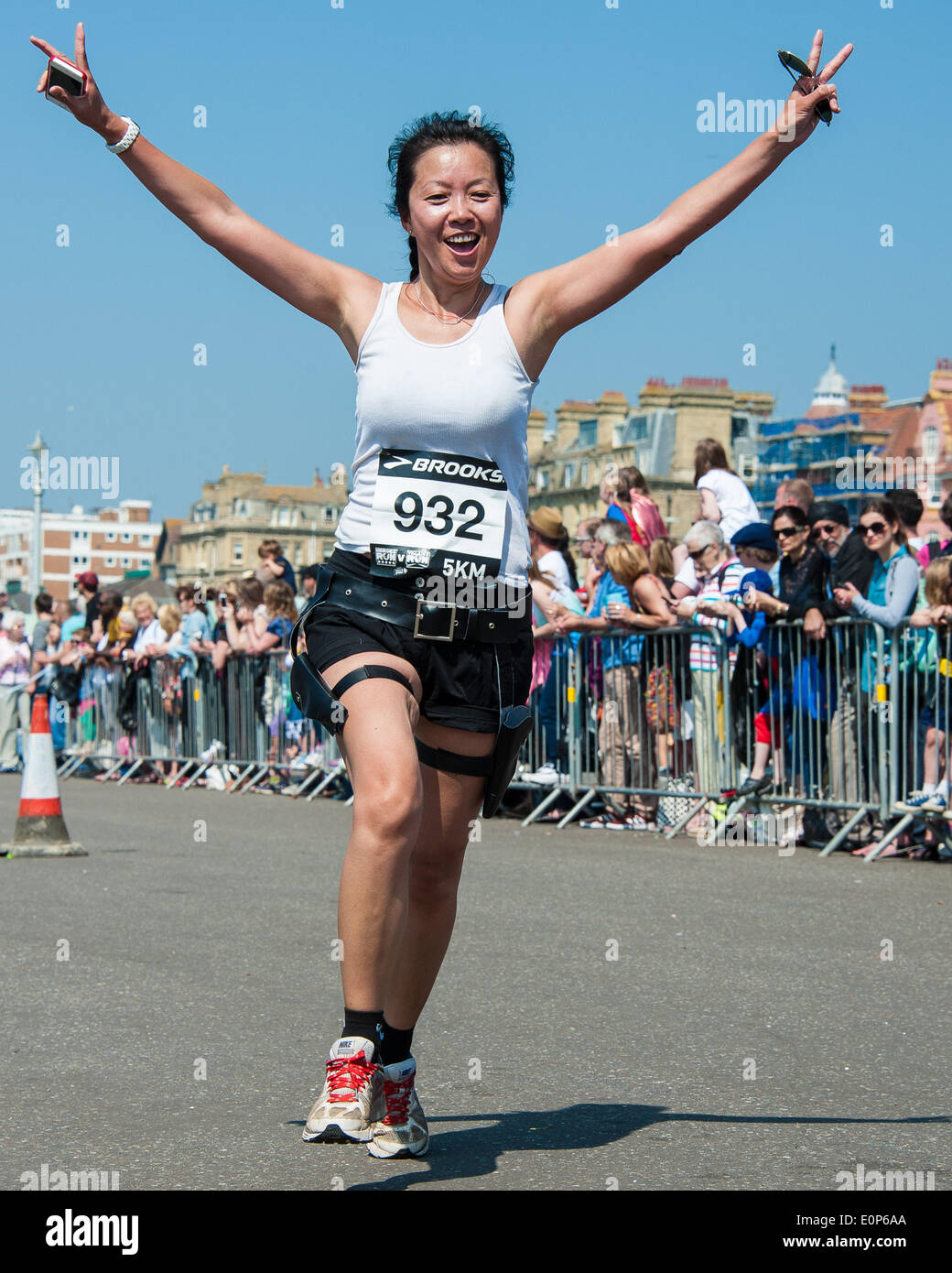 Brighton, UK. 18. Mai 2014. Die Ziellinie der Nächstenliebe Volkslauf auf Hove Promenade, um Gelder für, übergeben sie an Afrika. Verkleidet als Helden oder Schurken, die sie in der Sonne - einige mehr ernst nehmen als andere entlang sprint. die Kinder Rennen einen 500metre Kurs, Erwachsene, 5K oder 10K. Bildnachweis: Julia Claxton/Alamy Live-Nachrichten Stockfoto