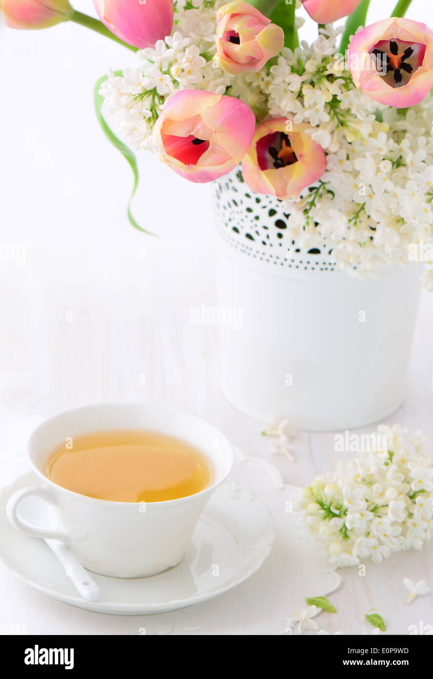 Schöne weiße Flieder und rosa Tulpen mit Tasse Tee für einen unterhaltsamen Nachmittag zu behandeln, mit Platz für text Stockfoto