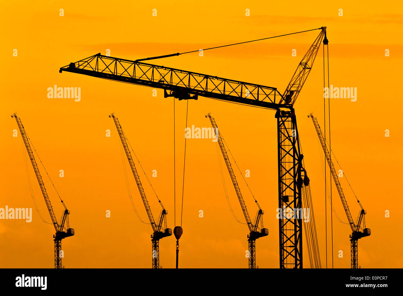 Industrielle Baukräne und Gebäude-Silhouetten Stockfoto