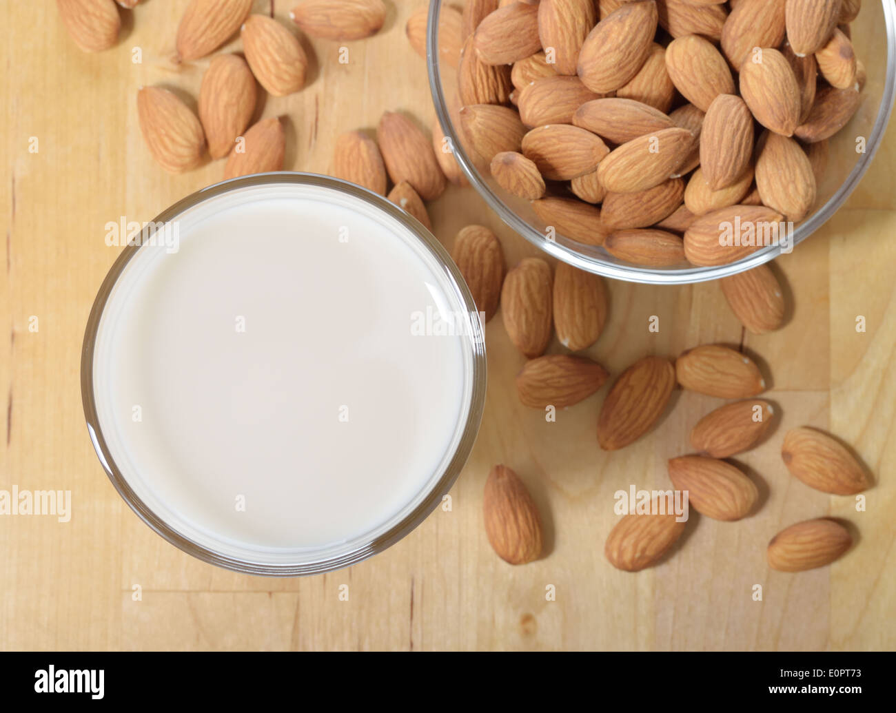 Mandel-Milch als Ersatz für Kuhmilch. Glas Mandelmilch und Mandeln auf einem Holztisch. Stockfoto