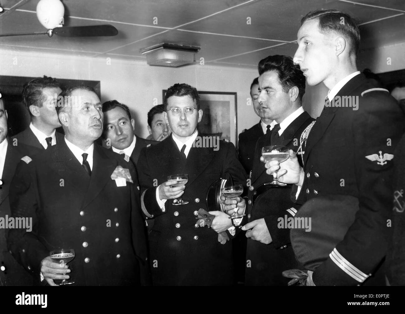 19. Dezember 1956; Bristol, UK; Admiral Barjot der französischen Marine lud die Presse vist versenkt sein Flaggschiff "Jean-Bart", berichtet wurde von den Ägyptern. Die "Jean Bart" liegt jetzt im Hafen von Toulon. Während des Empfangs, Admiral Barjot gratuliert den drei Marineoffiziere, die an den schwierigen Transport von teilgenommen "Hubschrauber des Kapitäns ein Schoner, der eine dringende Operation unterziehen musste. Das Bild zeigt ADMIRAL BARJT und die drei Offiziere: Naval Chirurg FICHOU, Mechaniker PICAL und Leutnant LOYER, Pilot des Hubschraubers. Stockfoto