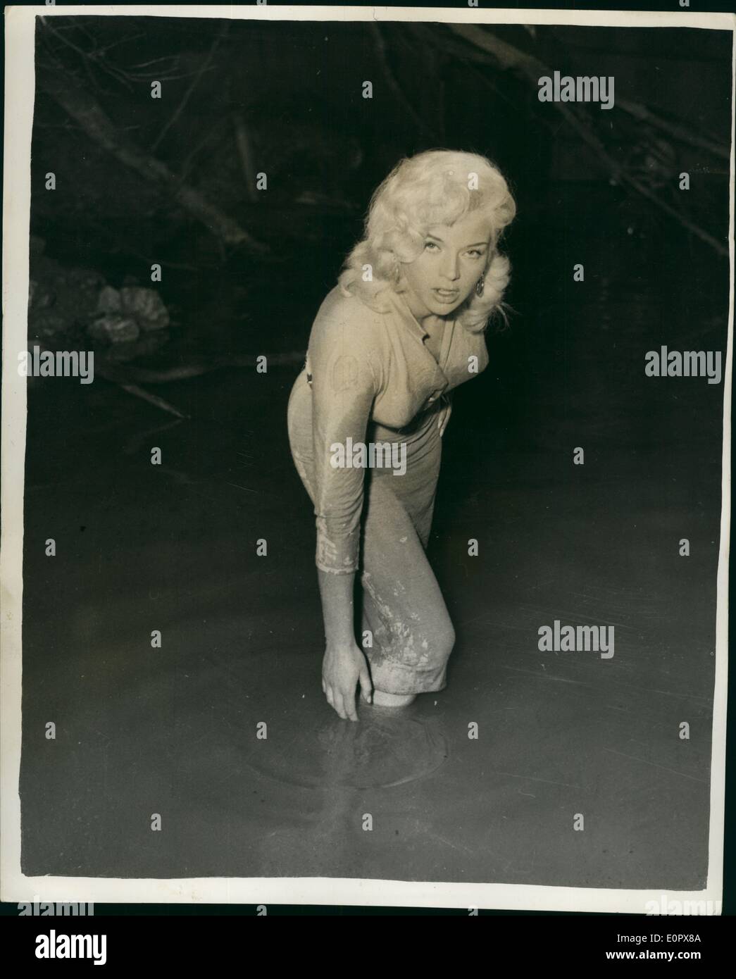 4. April 1957 - Benetzung für Diana - während Dreharbeiten zu Film: Während der Dreharbeiten des Films "The Long Haul'', die Shopper Tonne Studien gemacht werden, muss Windless, Diana Dors, wer die Rolle eines LKW Fahrers Freundin spielt Fllm in einen Fluss an, als sie versucht, zwei kämpfende LKW-Fahrer Teil. Foto zeigt Diana Dors, getränkt, Mus-bespattered, mit Wasser Swimiling um sie-während der Dreharbeiten des Films. Stockfoto