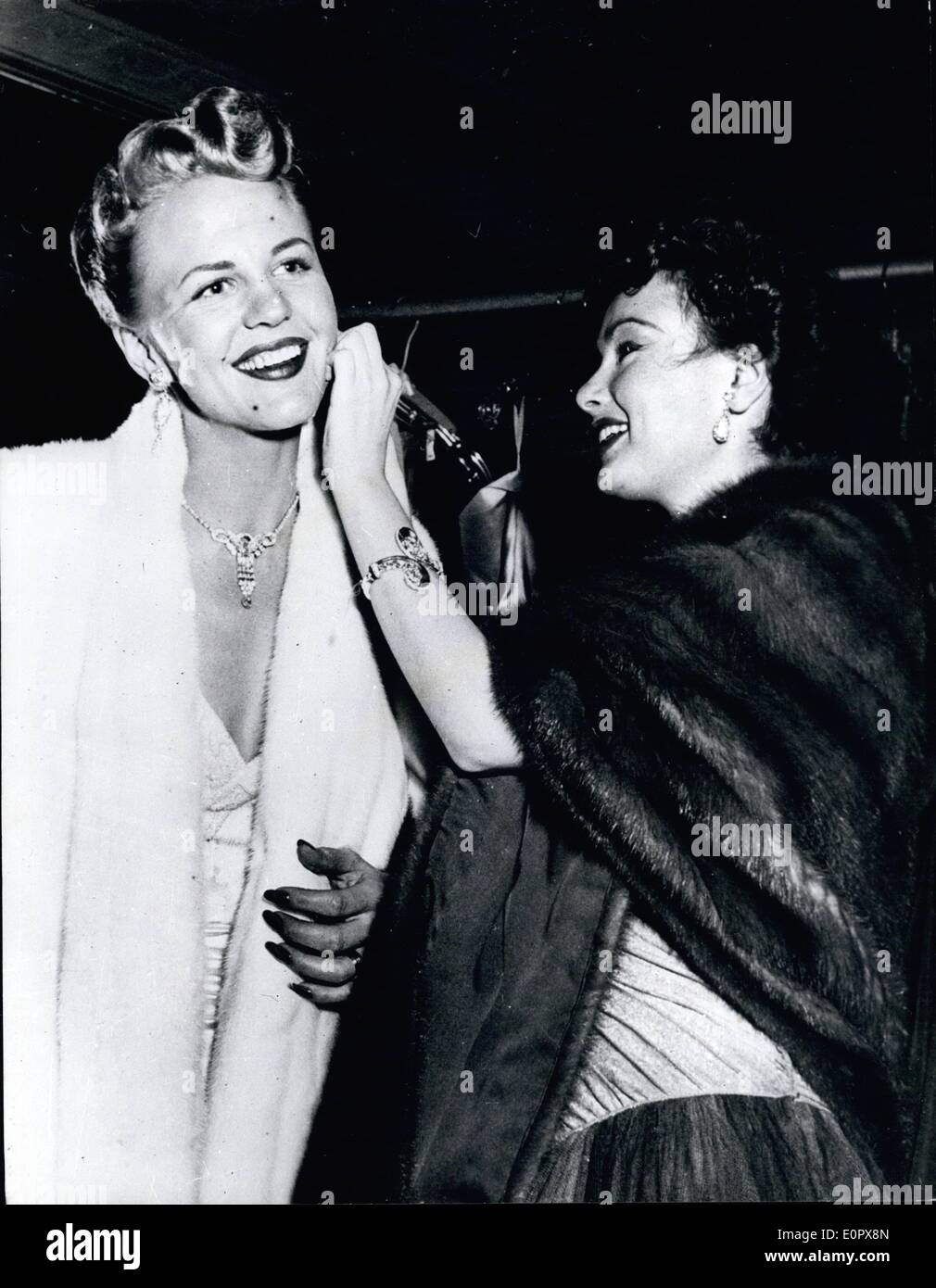 4. April 1957 - arbeiten Stars. Schöne Peggy Lee hat ihr Diamant Anhänger Ohrring befestigt durch lebhafte Coleen Gray... beide Stockfoto