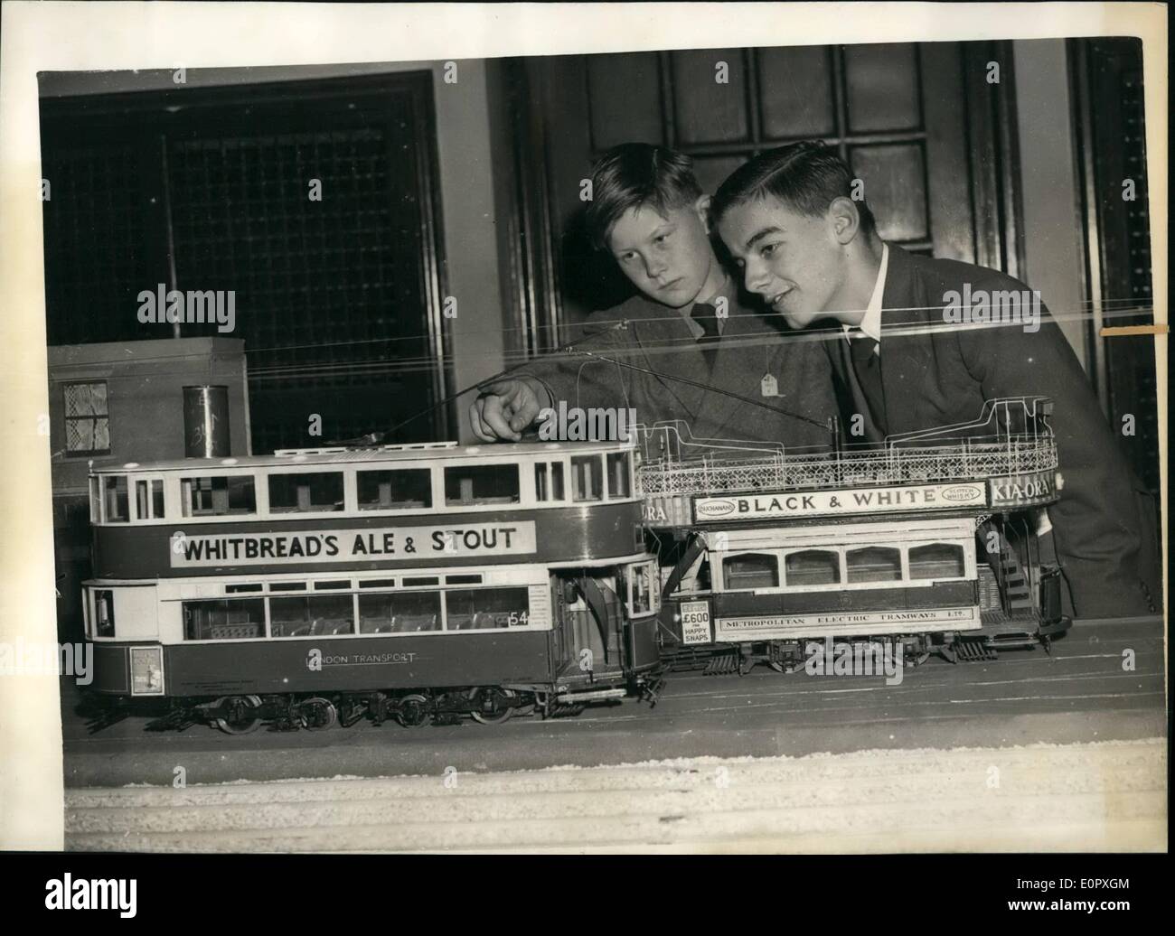 April 1957 - Eröffnung der Model Railway Exhibition Ancient Trams: Clive Ewen (10) von Crowthorn, Berks - und Reginald Davis (14) von Streatham - bewundern Modelle einer London Transport Tram - und rechts eine alte Metropolitan Electric Tram - auf der Model Railway Exhibition, die in der Central Hall in Westminster stattfindet. Stockfoto