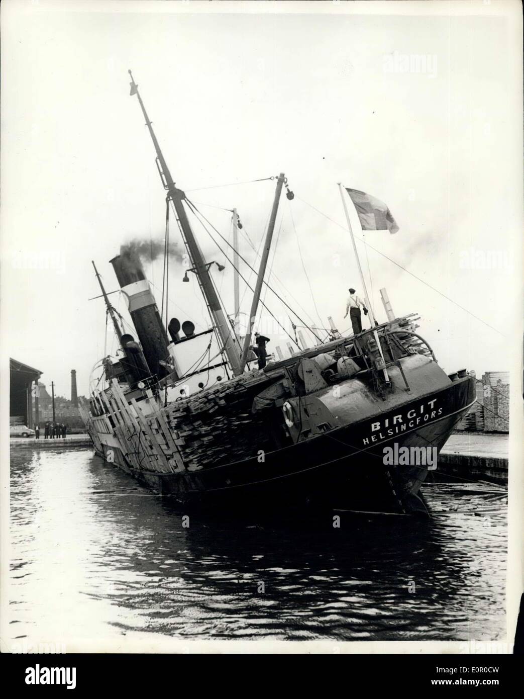 12. Juli 1957 - Schlepper halten Frachtschiff hat eine Liste mit Anschluss in London Docks: Foto zeigt der finnische Dampfer '' Birgit'' mit einer Liste zum Hafen in Surrey Docks, London, heute gesehen. Sie ist mit 3.000 Tonnen Holz geladen, Stauer weigerte sich, an Bord zu gehen, wie sie behaupten, dass es zu gefährlich ist. Das Schiff ist von Schleppern statt. Stockfoto