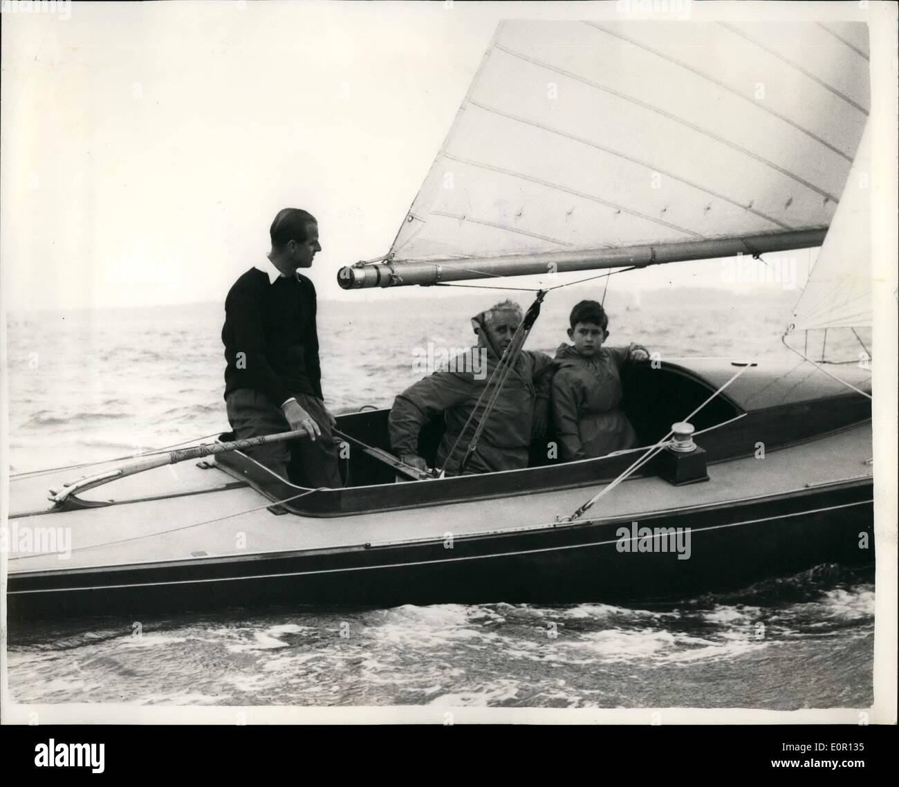 8. August 1957 - geht Prinz Charles Yacht Racing - mit seinem Vater... an Bord der "Zusammenarbeit" zu sehen.: Prinz Charles begleitete seinen Vater Duke of Edinburgh in die '' Zusammenarbeit '' in einem Dragon Klasse Rennen im Wettbewerb eine während der Regatta Cowes heute. Foto zeigt Wearing eine wasserdichte Latzhose Prinz Charles zwischen MFFA Fuchs und Kommandant Kapitänleutnant a.t. Easton - in der "Zusammenarbeit" - sitzen in Cowes heute. Stockfoto