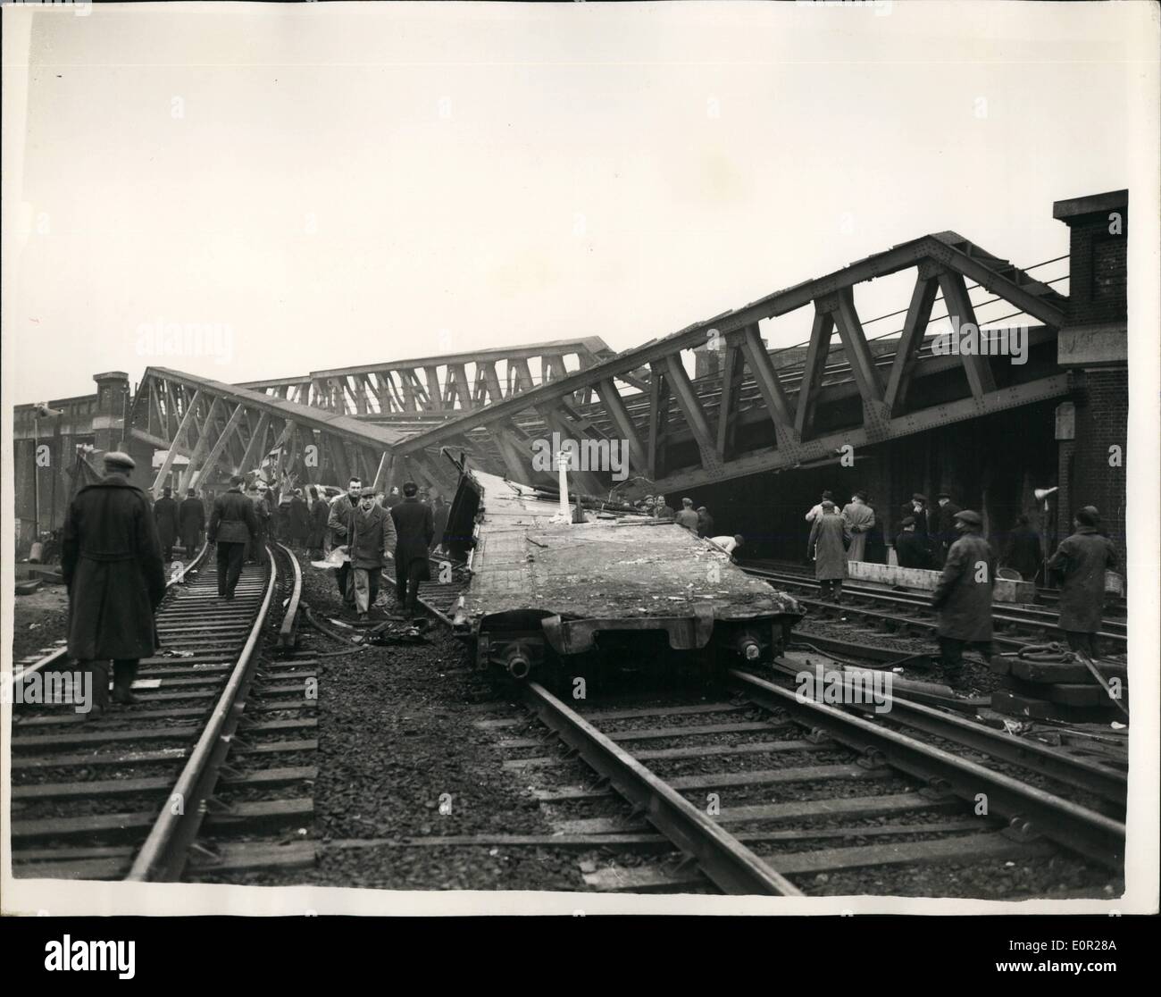 12. Dezember 1957 - geht Rettungsarbeit weiter in der Lewisham Rail Crash-Ingenieure versuchen, die Fly-Brücke zu erhöhen. Die Todesrolle hat 92 erreicht. in Mittwoch Abend Lewisham Schiene Abbruch. Retter haben ganze Nacht geschuftet unter sind Lichter und früh Ingenieure versuchten o Erhöhung der zerstörten Brücke um der Trainer zu löschen, auf denen das volle Gewicht der Straßenüberführung Brücke fiel. Foto zeigt die ersten klaren Bild von der Katastrophe getroffen, nachdem der Nebel angehoben hatte heute zeigen die Fly-over-Brücke, die zusammengebrochen auf einen der Züge nach dem Absturz Stockfoto