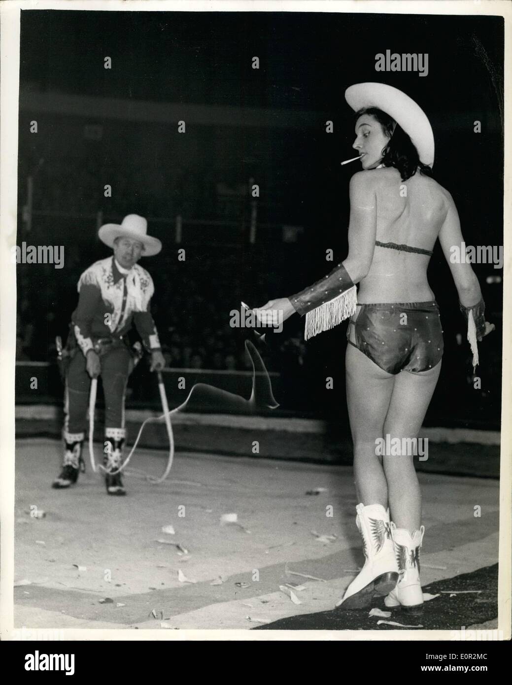 12. Dezember 1957 - Proben für Olympische Weihnachtszirkus: Foto zeigt eine der Handlungen im Bertram Mills Circus Olympia eine Probe davon heute fand - ist das Cordon des - in dem Whipcracking sensationelle Natur gesehen wird, in dem ein Spiel - ein Mädchen im Besitz befindet sich in Ordnung durch die Peitsche - gefolgt von den streichen einer Zigarette im Mund gehalten. Stockfoto