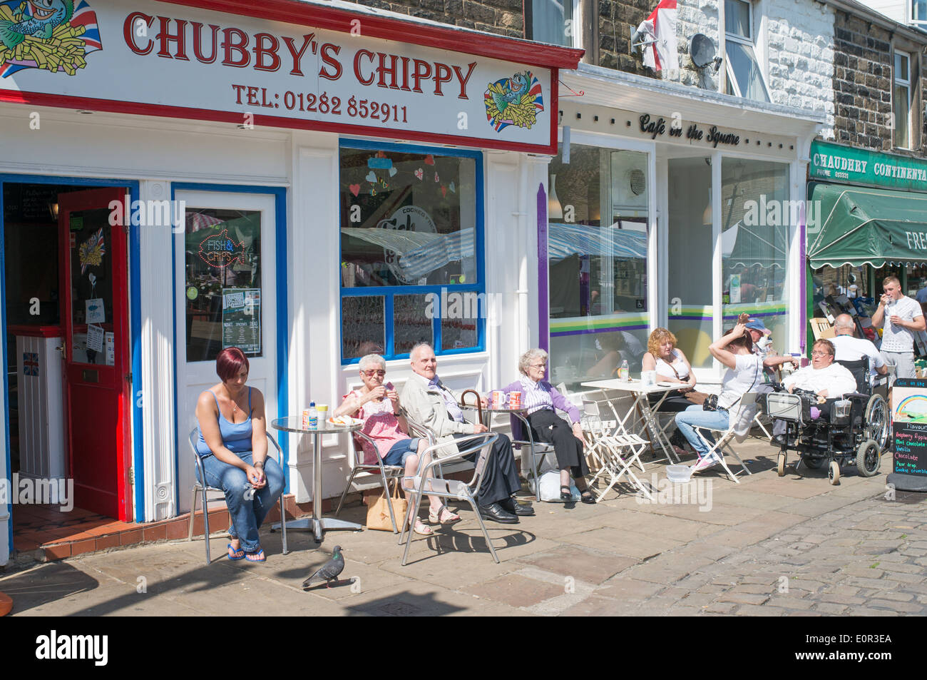 Menschen sitzen vor Café in Barnoldswick, Lancashire, UK Stockfoto