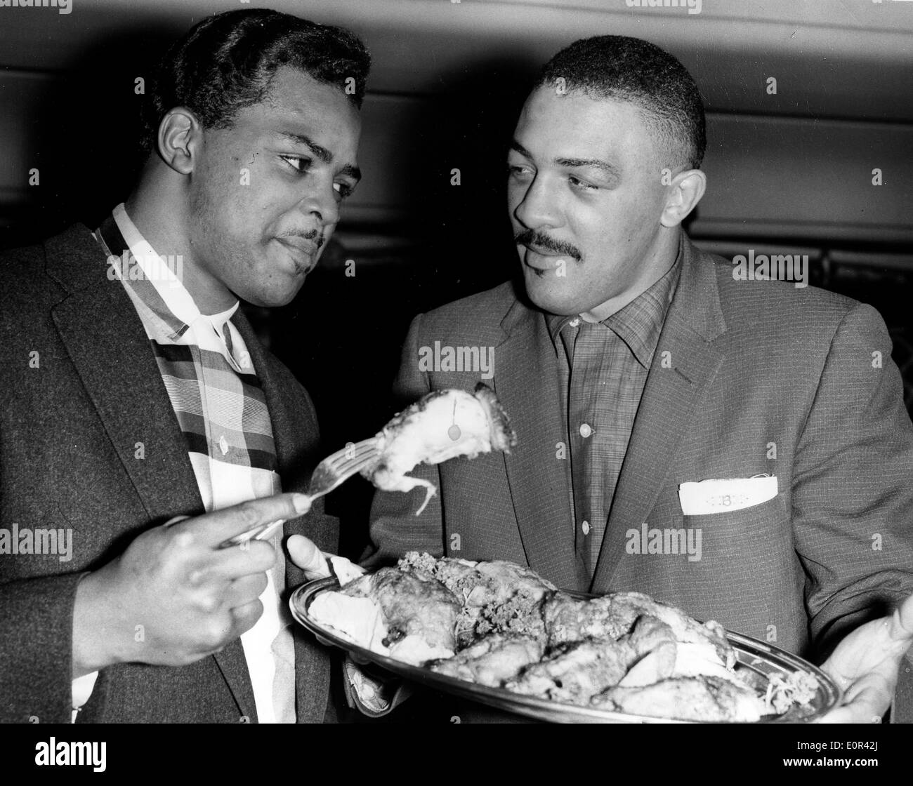 Boxer Bob Baker ein Hühnerbein von Howie Turner angeboten Stockfoto