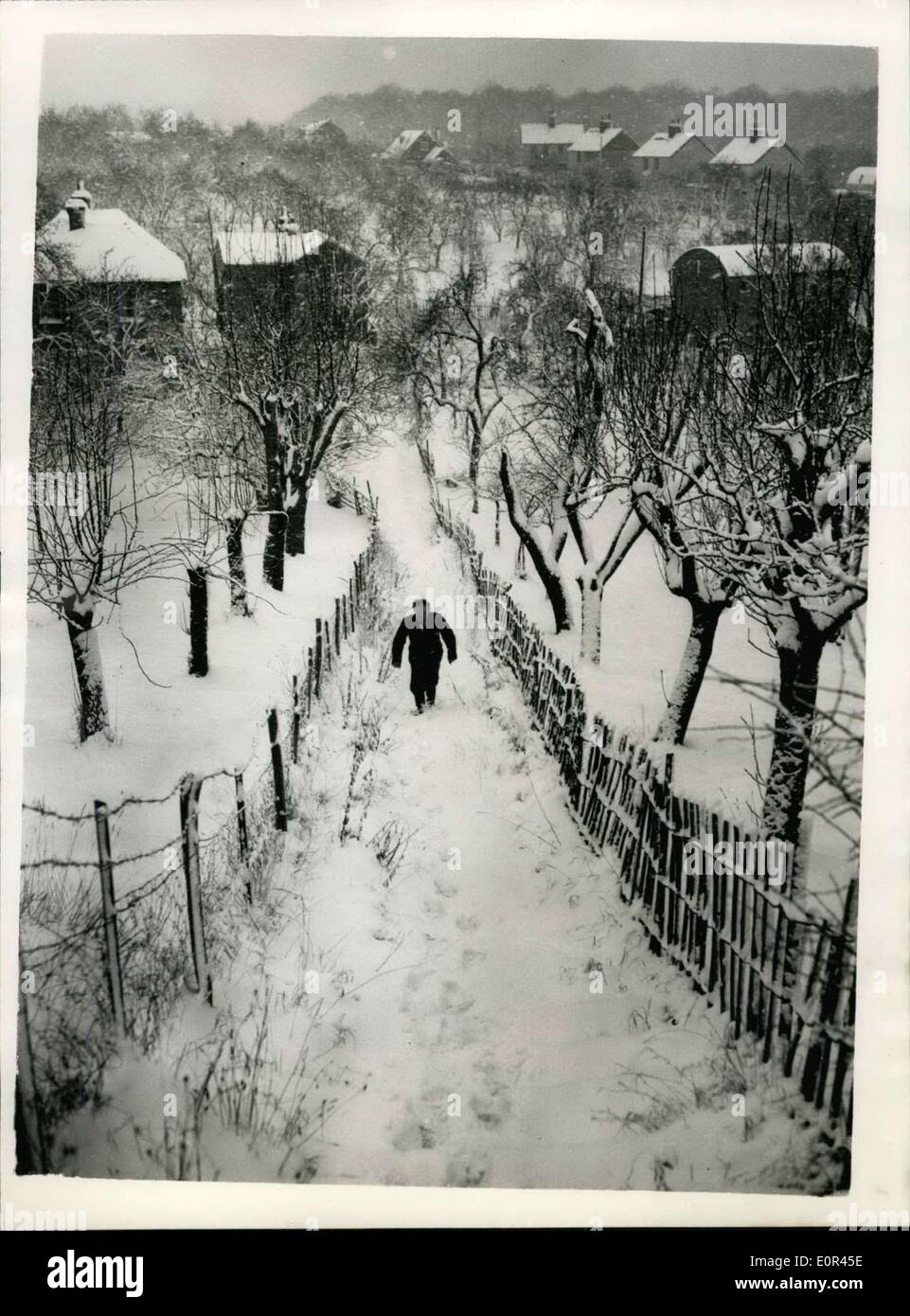 22. Januar 1958 - Kent-Städte und Dörfer abgeschnitten von Schnee driftet hübsche Szene, in der Nähe von Faversham: viele Städte und Dörfer in Kent wurden Sie durch die schwere Schneewehen, die die schlimmsten Schneestürme seit zwei Jahren folgten. Straßen waren blockiert, und an einigen Stellen gab es bis zu 18 Zoll von Schnee. Foto zeigt die schöne Szene, wie ein Dorfbewohner die Schnee bedeckten Schritte in einem Dorf in der Nähe von Faversham, Kent heute klettert. Stockfoto