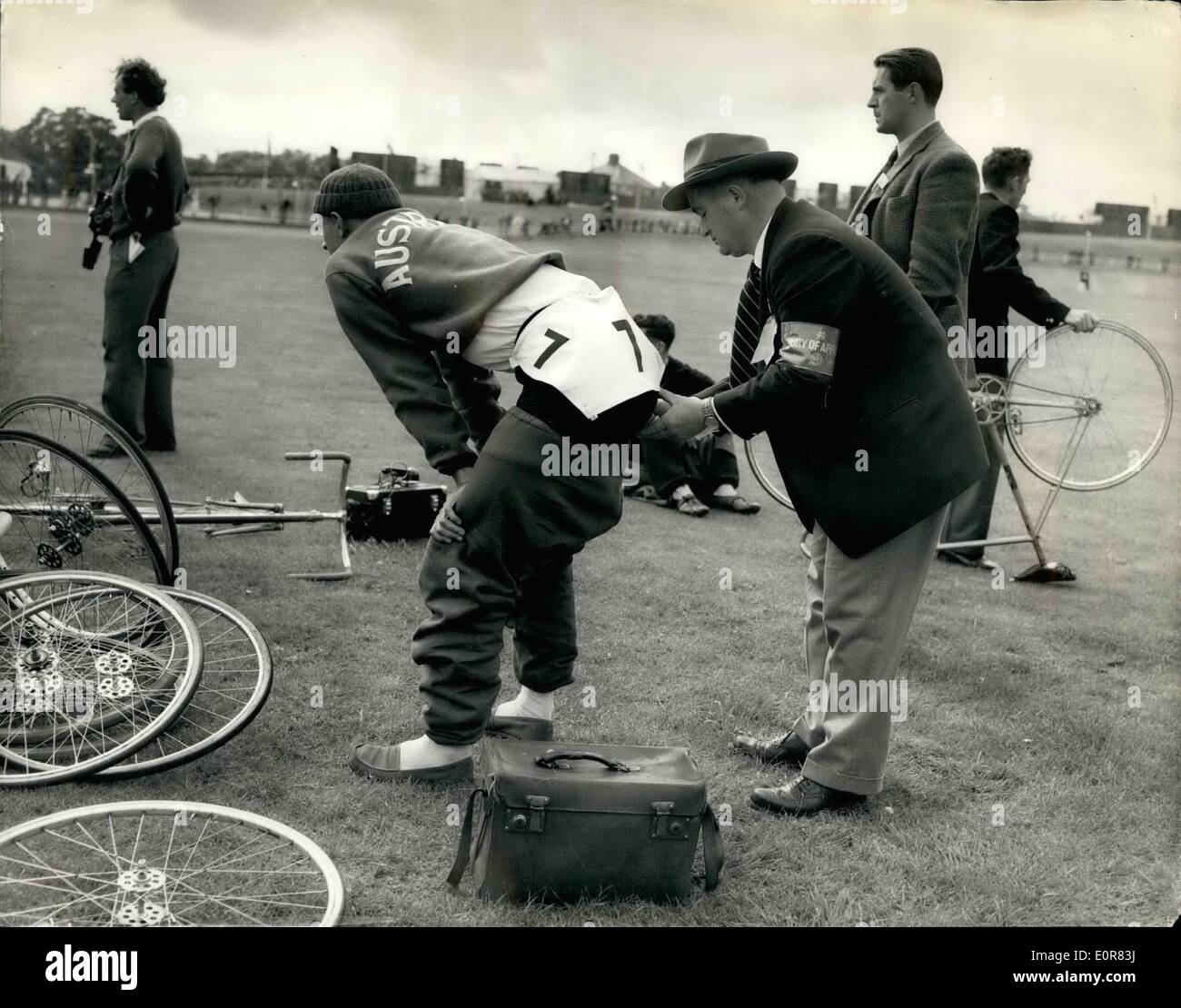 7. Juli 1958 - British Empire Games; Seine Hosen sind nummeriert. Foto zeigt Ron O'Donneil, das australische Team Manager, pins die Startnummer auf die Hose von Warren Scarfe, von Australien, die im 1000-Meter Rad vorne Sprint erwärmt - wie Cardiff, gestern bei den British Empire and Commonwealth Games im Wettbewerb war. Stockfoto