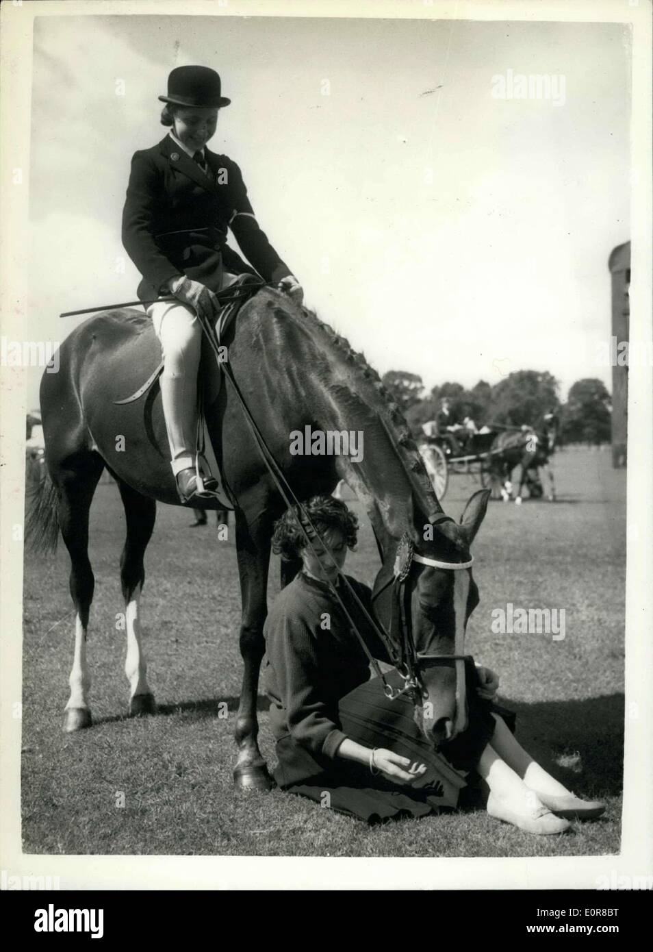 2. August 1958 - Horse Show On Clapham Common: Foto zeigt das beste pony in die Kinder offener Pony-Wettbewerb '' Klamisa'', Reiter,. Miss Penny Hart, 14 von Hedgeley, Böcke, entspannt nach die Veranstaltung, Jane Thursby, ein Modell der gemeinsamen Farnham, zwischen den Vorderbeinen Pferde - bei der Clapham Common Horse Show, heute sitzt. Stockfoto