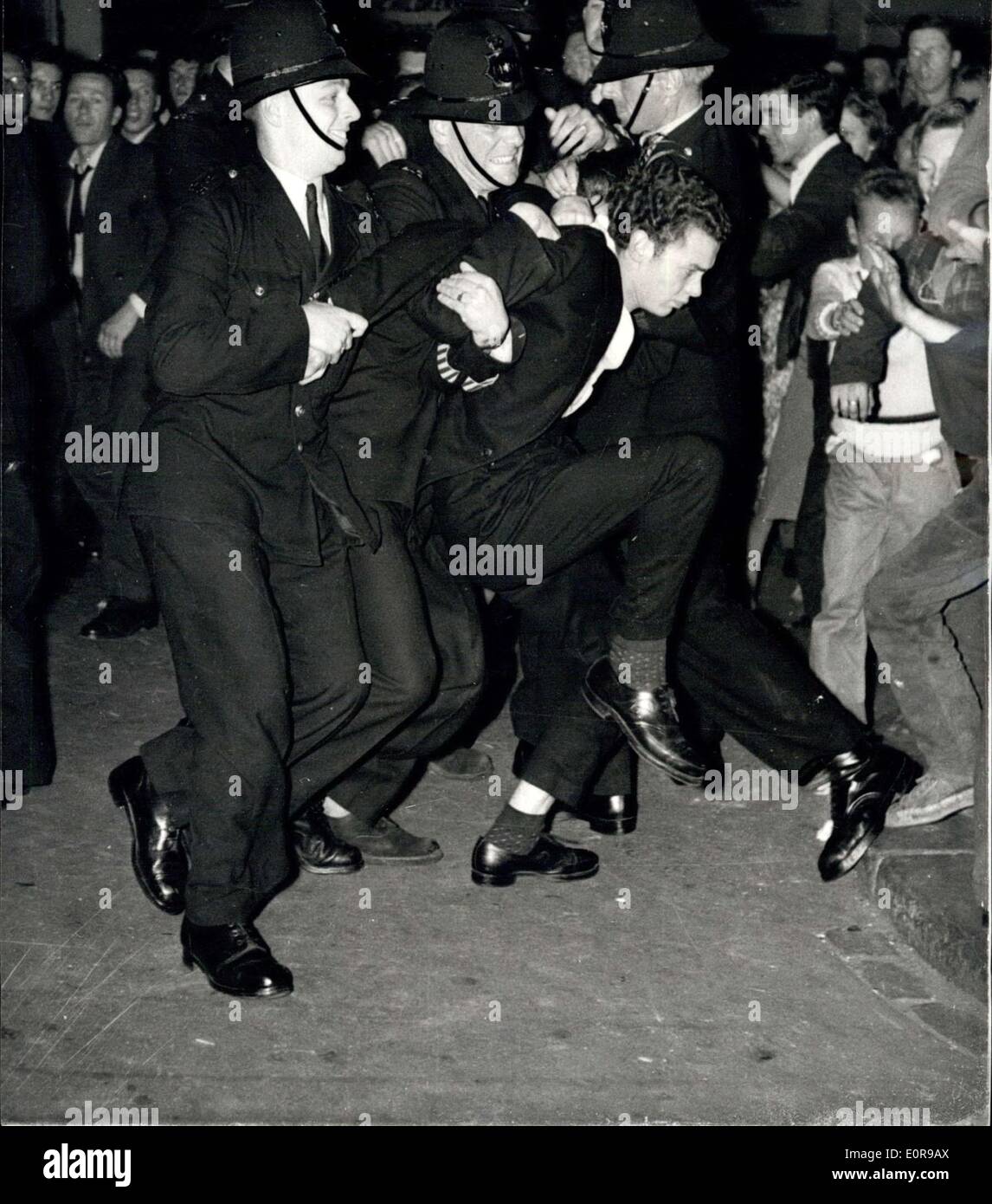 Sep 01, 1958 - '' Farbe '' Krawalle in Notting Hill Gate. Ein Demonstrator ist marschierten off: Polizei Verstärkungen waren zu London Notting Hill Gate gestern Abend stürzte, wie '' Farbe '' brachen Unruhen aus zum zweiten Mal innerhalb von vierundzwanzig Stunden. Zum zweiten Mal innerhalb von vierundzwanzig Stunden brachen die Unruhen aus. Die Unruhen begann, nachdem weiße Jugendbanden bei farbigen Menschen verhöhnt hatte. Ca. dreizehn Personen wurden festgenommen - und eine Reihe mit zerbrochenen Flaschen etc. verletzt wurden. Foto zeigt, dass die Polizei einem Randalierer entfernt während der Demonstrationen in Notting Hill Gate marschieren. Stockfoto