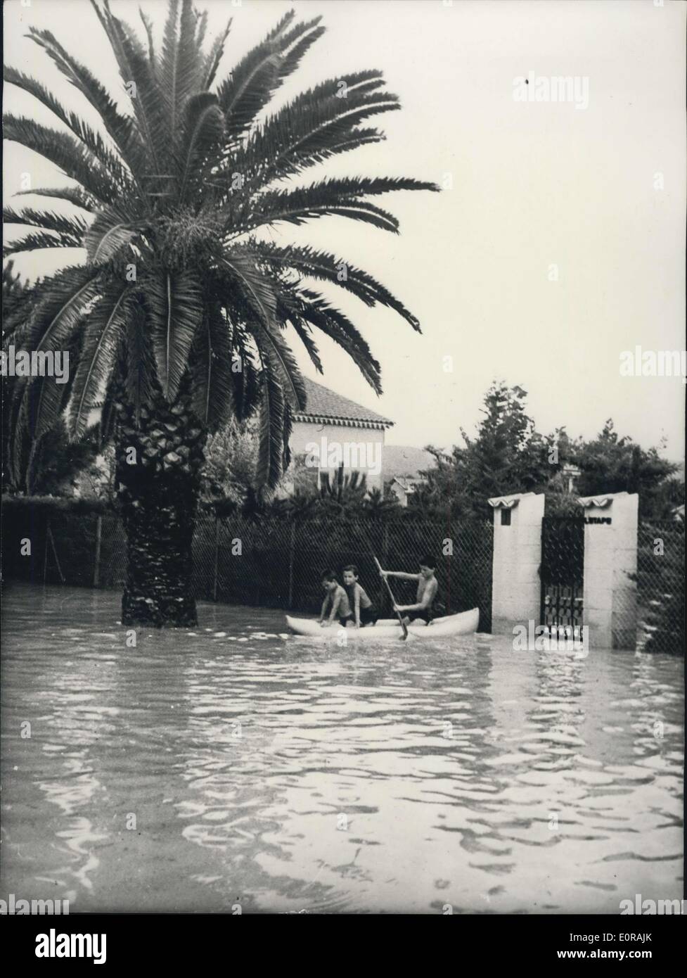 Sept. 19, 1958 - Sturm und In Southren Frankreich: Foto zeigt kleine Jungs in Baden Hosen gesehen, Paddeln in einem kleinen Boot auf dem Weg des Lecques, in der Nähe von Toulon. Die Palme teilweise unter Wasser verschwinden. Stockfoto