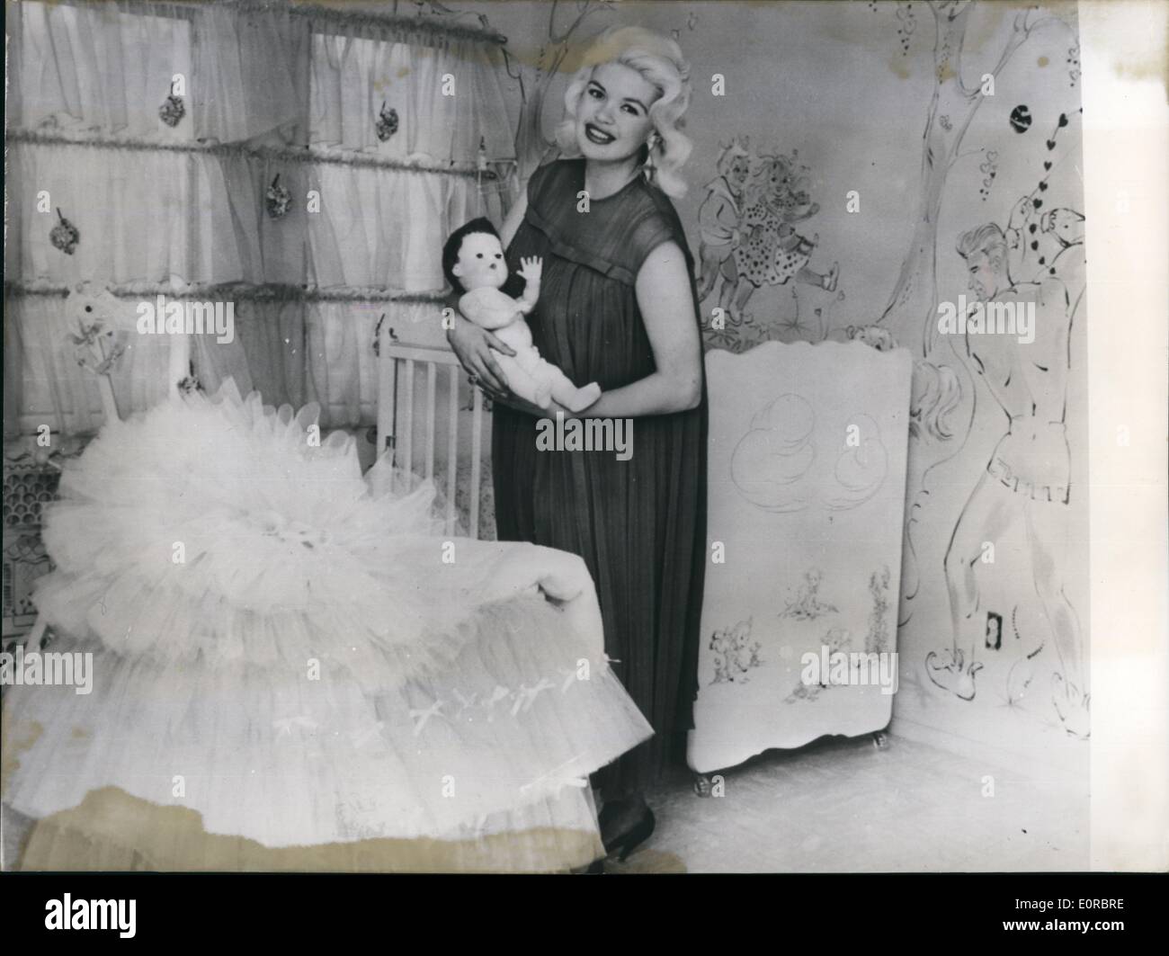 1. Januar 1959 - eine glückliche Mutter... ist die Hollywood-Schauspielerin Jayne Mansfield, Fotoshows Jayne im Babyzimmer ihres Hauses mit einer Marionette vor der Geburt gekauft. Das kleine Baby wird vielleicht nicht so, dass dieses Spielzeug für es ein Junge ist, der den Vornamen seines Vaters Mickey Hargitay bekam. Stockfoto