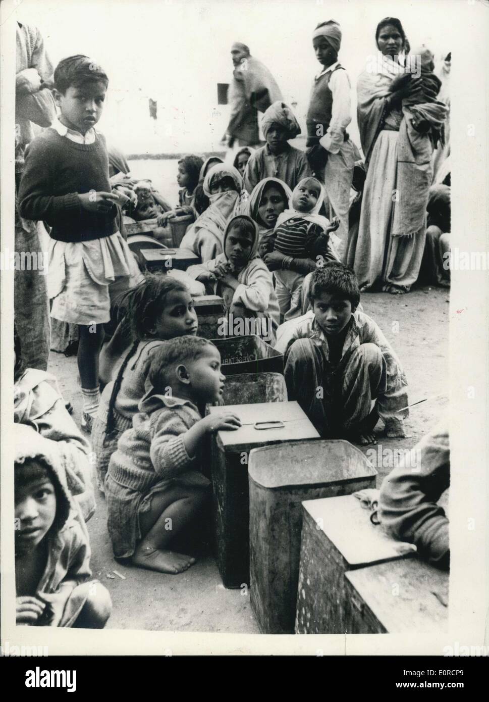 16. Januar 1959 - Nahrungsmittelknappheit in Delhi, Warteschlange für Getreide; Ständigen Mangel an Nahrungsmitteln in Delhi stellt nun eine Bedrohung für Recht und Ordnung in der indischen Hauptstadt. Lange Schlangen von Frauen und Kindern, die auf eine Mahlzeit eine Tag Form in den Geschäften der Korn-Händler Leben, die ihre Preise in den letzten zwanzig Tagen 25 % erhoben haben. Die Menschen fordern die Regierung 40 '' fairen Preis '' Geschäfte geöffnet. Foto zeigt Frauen und Kinder sitzen geduldig wartet die Korn-Geschäfte in Delhi mit ihren großen Getreidesilos zu öffnen. Die Lebensmittelknappheit ist so akut, dass der Händler ihnen nur eine Rupie Wert pro Tag ermöglichen. Stockfoto