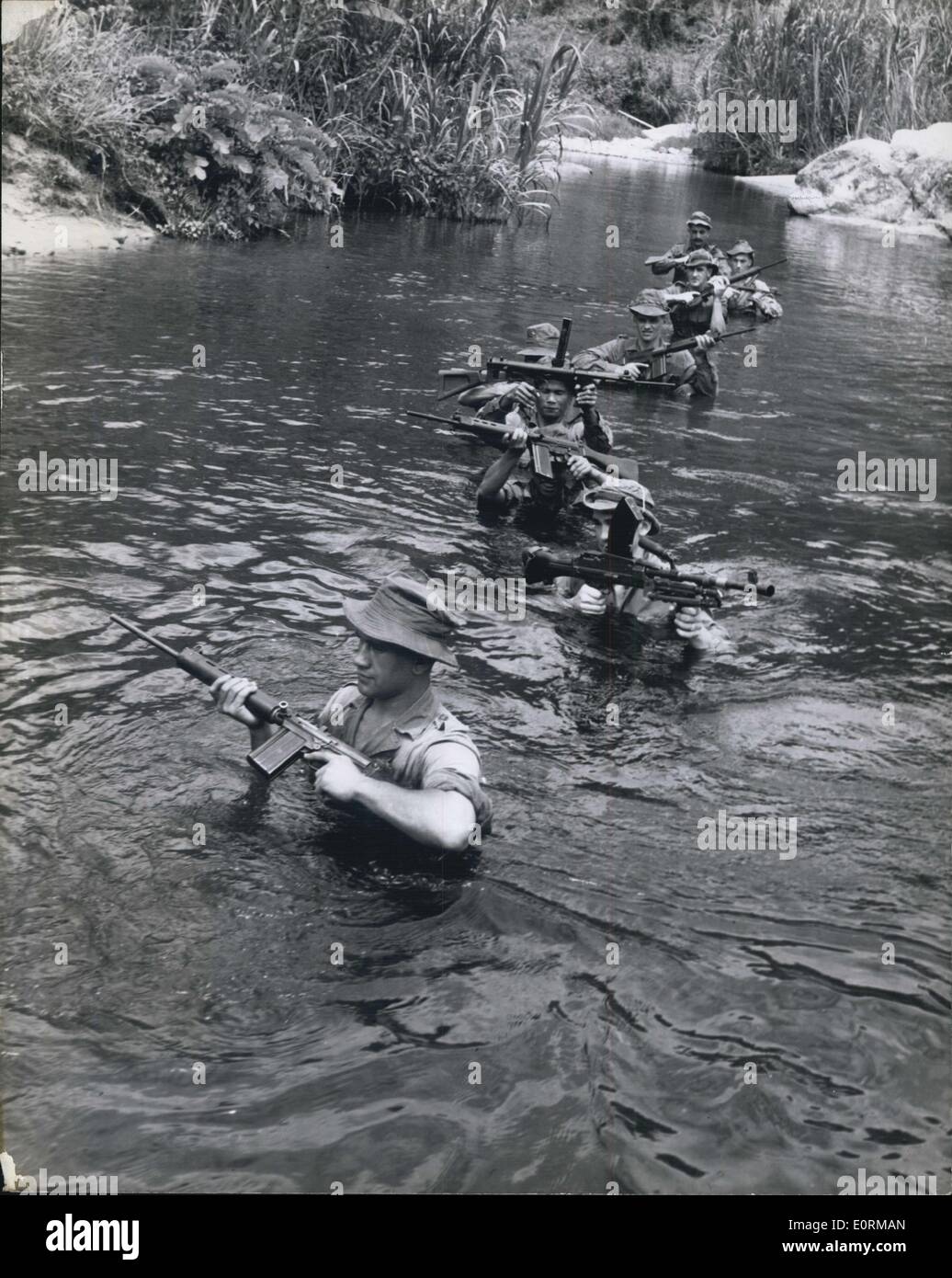1. Januar 1960 - auf Patrouille in Malaya: Terrorist Hunt geht noch weiter. Brust-tief im Fluss, dieser Patrouille macht seinen Weg flussaufwärts während einer Dschungel-Patrouille. Waffen haben eine erhebliche körperliche Belastung auf Schulterhöhe gehalten werden. Stockfoto