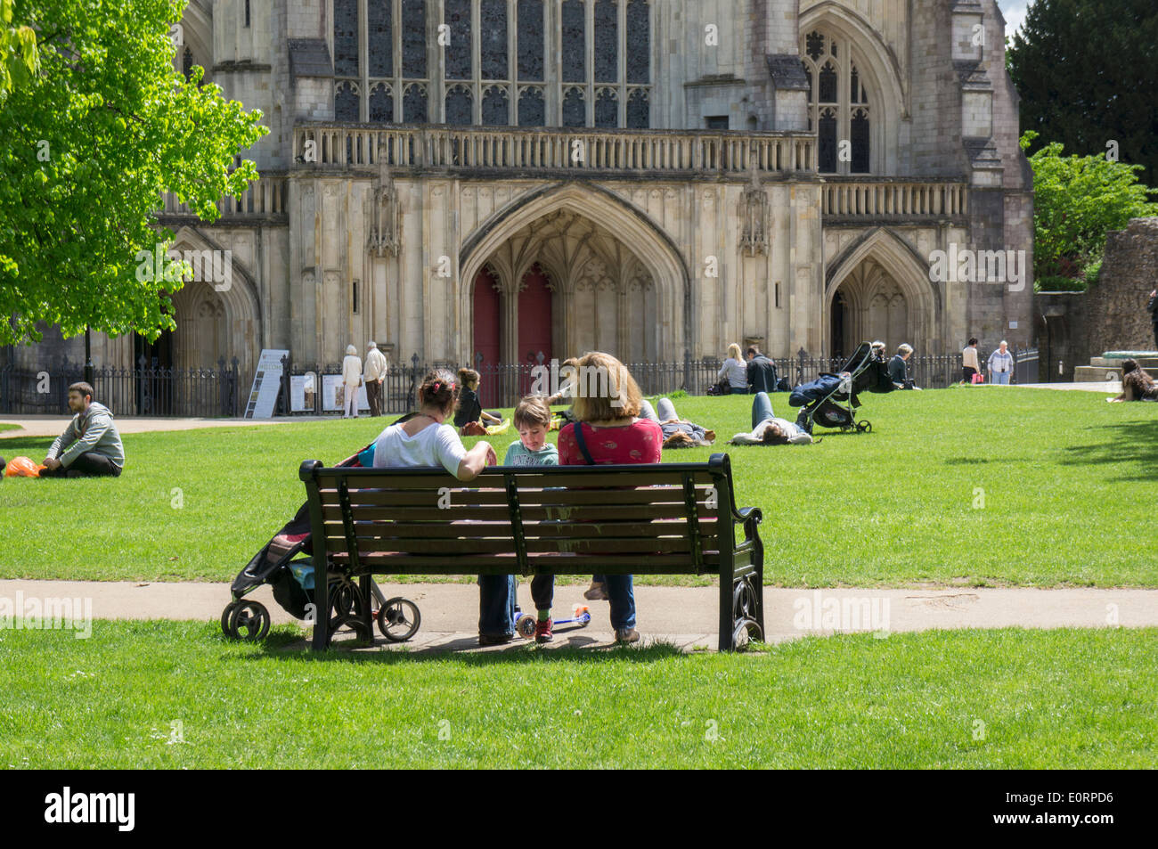 Menschen entspannen im Park außerhalb der Kathedrale von Winchester, Hampshire, England, UK Stockfoto