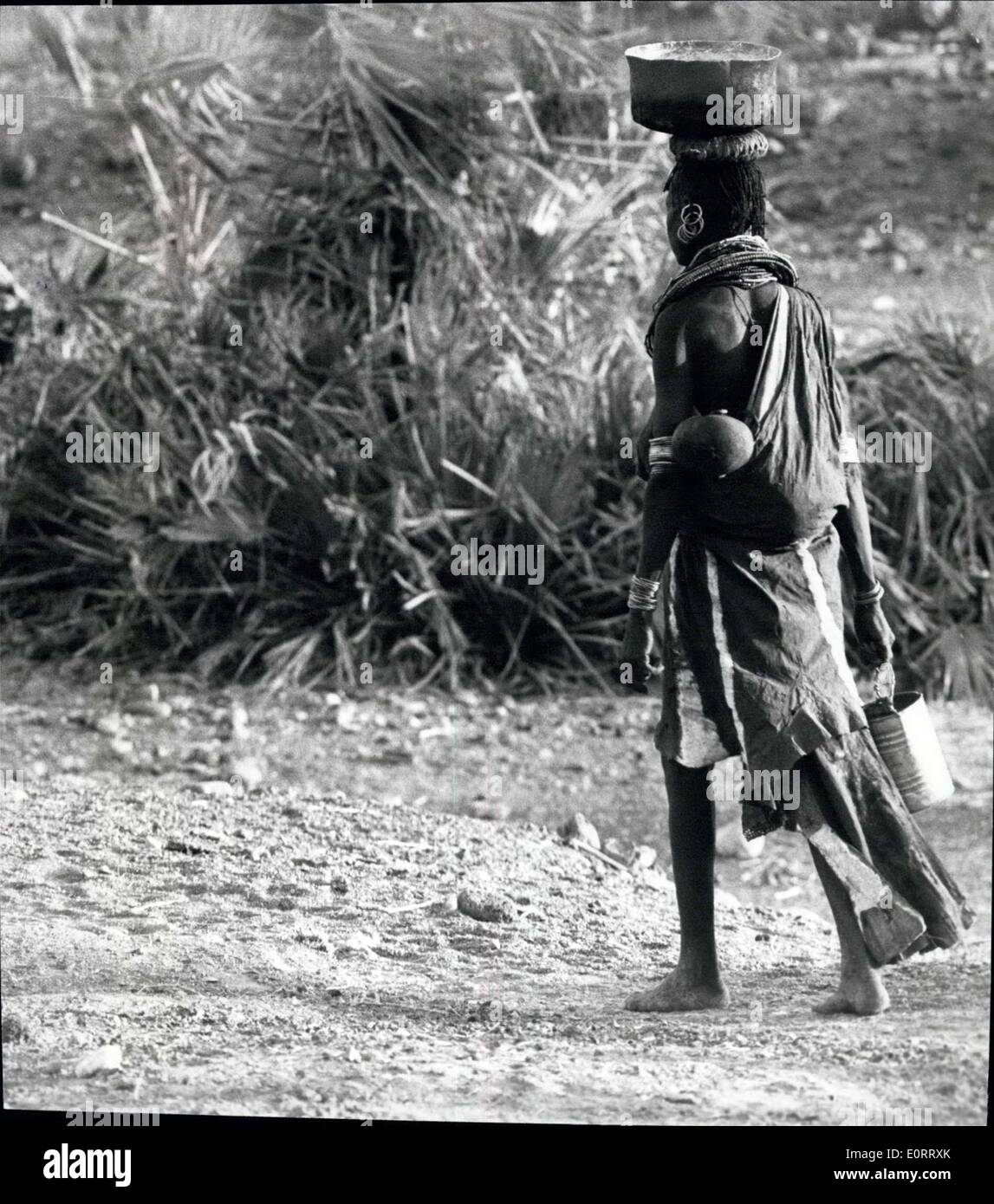 8. Mai 1960 - trägt El Molo Frau ihr Baby auf dem Rücken und ihr Schüssel Essen auf dem Kopf im altehrwürdigen afrikanische Mode. Stockfoto