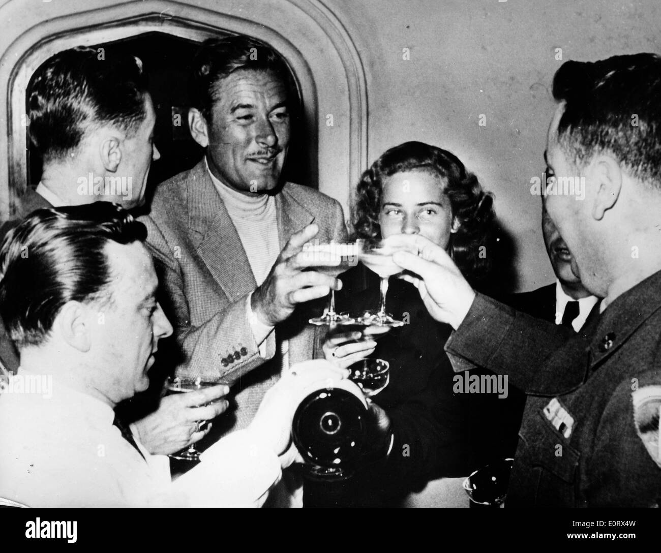 Schauspieler Errol Flynn Toast sein Glas mit Freunden Stockfoto