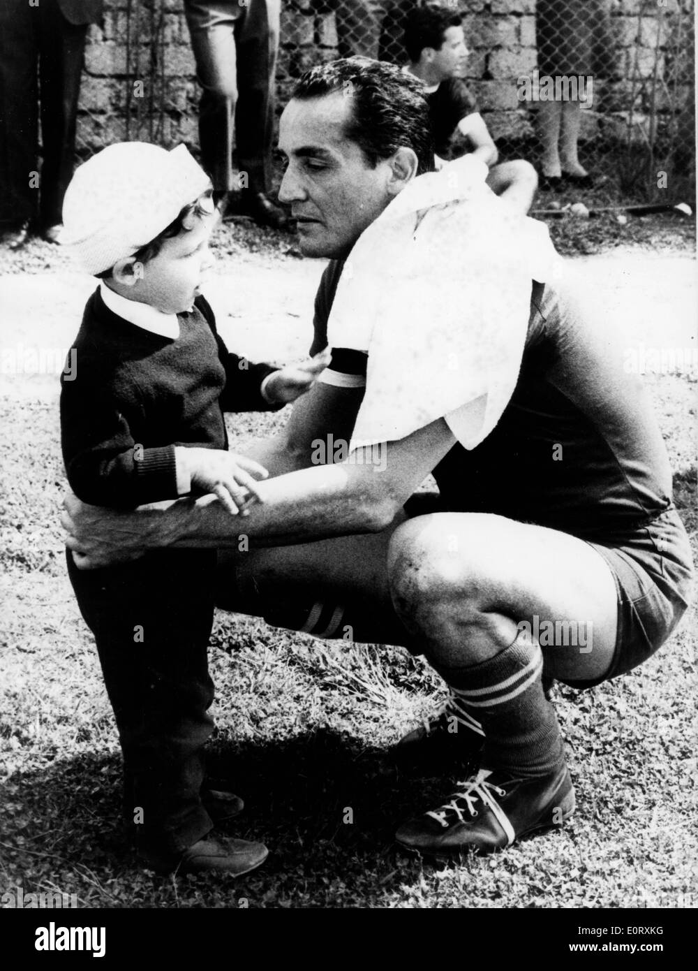 Schauspieler und Regisseur, VITTORIO GASSMAN kniet und mit einem Kind spricht. Stockfoto