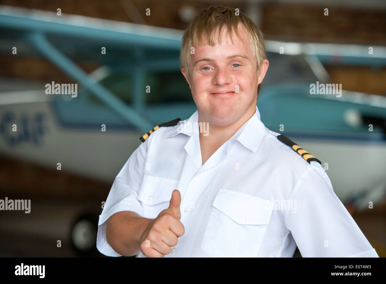 Jungen Piloten mit Down-Syndrom zeigen, Daumen nach oben. Stockfoto