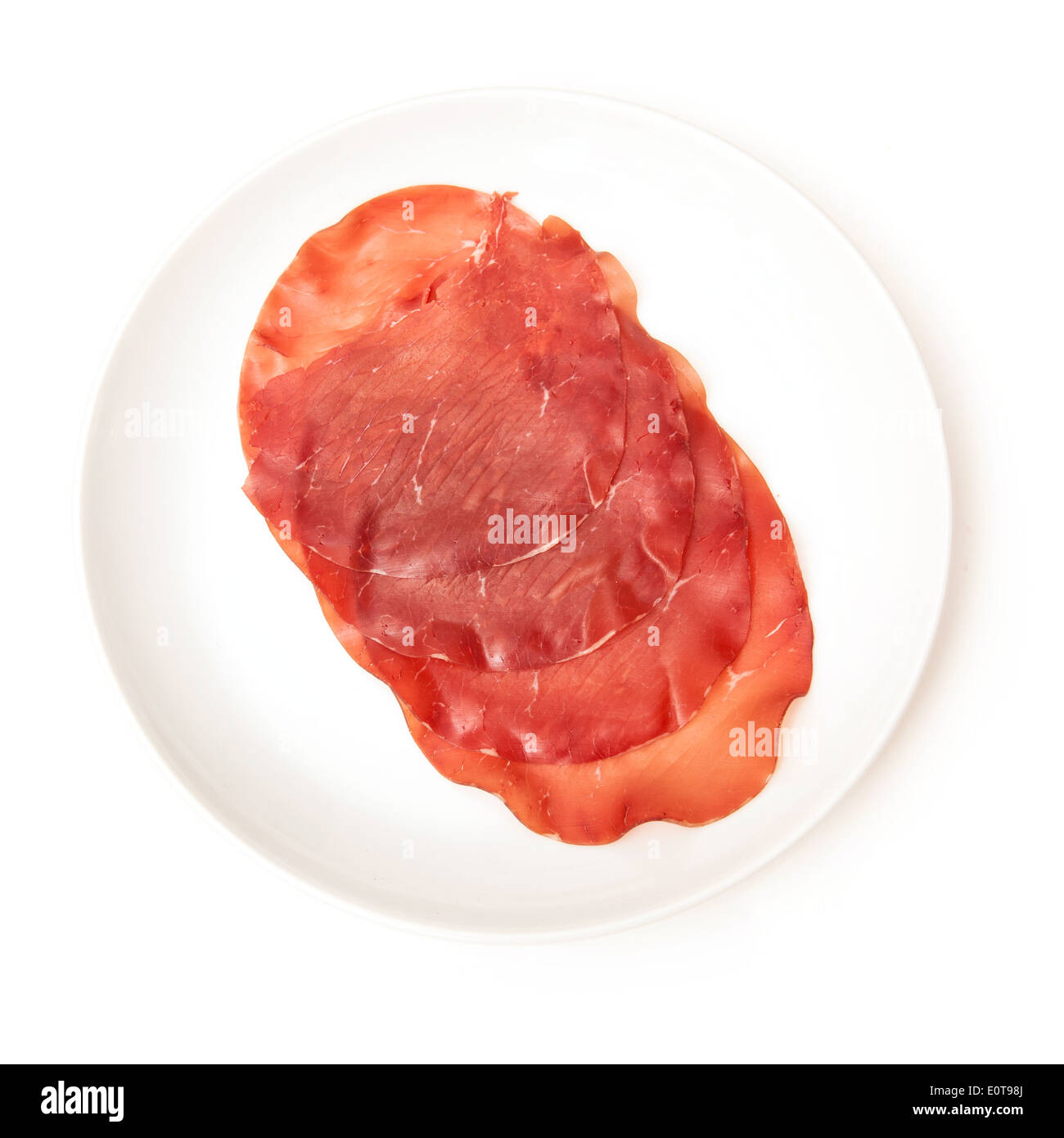 Teller mit Bresaola Della Valtellina P.G.I - italienische Luft getrocknetes Rindfleisch-Scheiben isoliert auf einem weißen Studio-Hintergrund. Stockfoto