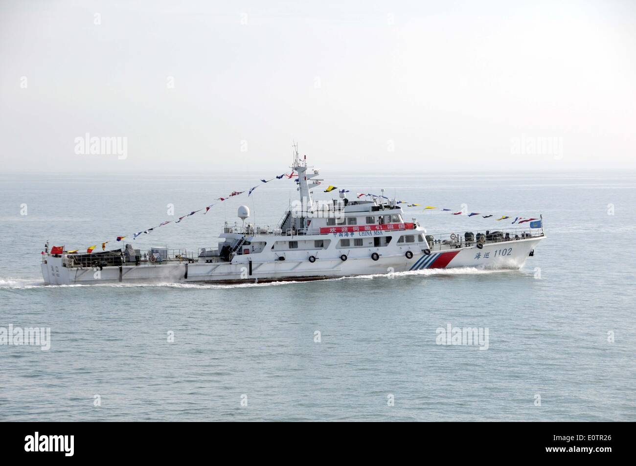 (140520)--an Bord WUZHISHAN, 20. Mai 2014 (Xinhua)--A Chiense marine Patrouillenschiff zeigt ein Banner "Welcome Home" für chinesische Staatsangehörige an Bord das Passagierschiff Wuzhishan als Wuzhishan Schiff Köpfe nach Haikou, der Hauptstadt der Provinz Süd-China Hainan, 20. Mai 2014. Die erste Gruppe von Gewalt heimgesuchten chinesische Arbeiter in Vietnam angekommen im Hafen von Haikou am Dienstagmorgen. Die chinesische Regierung schickte vier Schiffe am Sonntag Aufstand heimgesuchten chinesische Arbeiter in Vietnam zu evakuieren, wo schwere Gewalt gegen ausländische Unternehmen seit Mai 13 zwei chinesische Staatsbürger Toten und vieles mehr hinterlassen hat Stockfoto