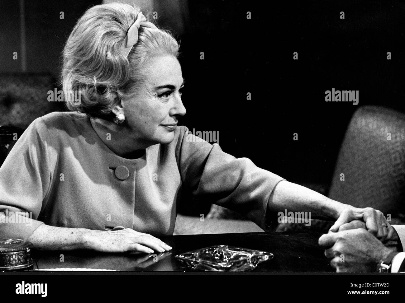 Schauspielerin Joan Crawford an einem Tisch sitzen Stockfoto