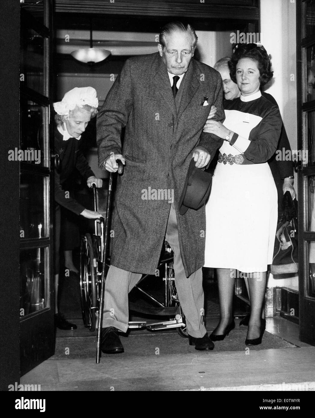 Krankenschwester hilft Premierminister Harold Macmillan aus Stuhl Stockfoto